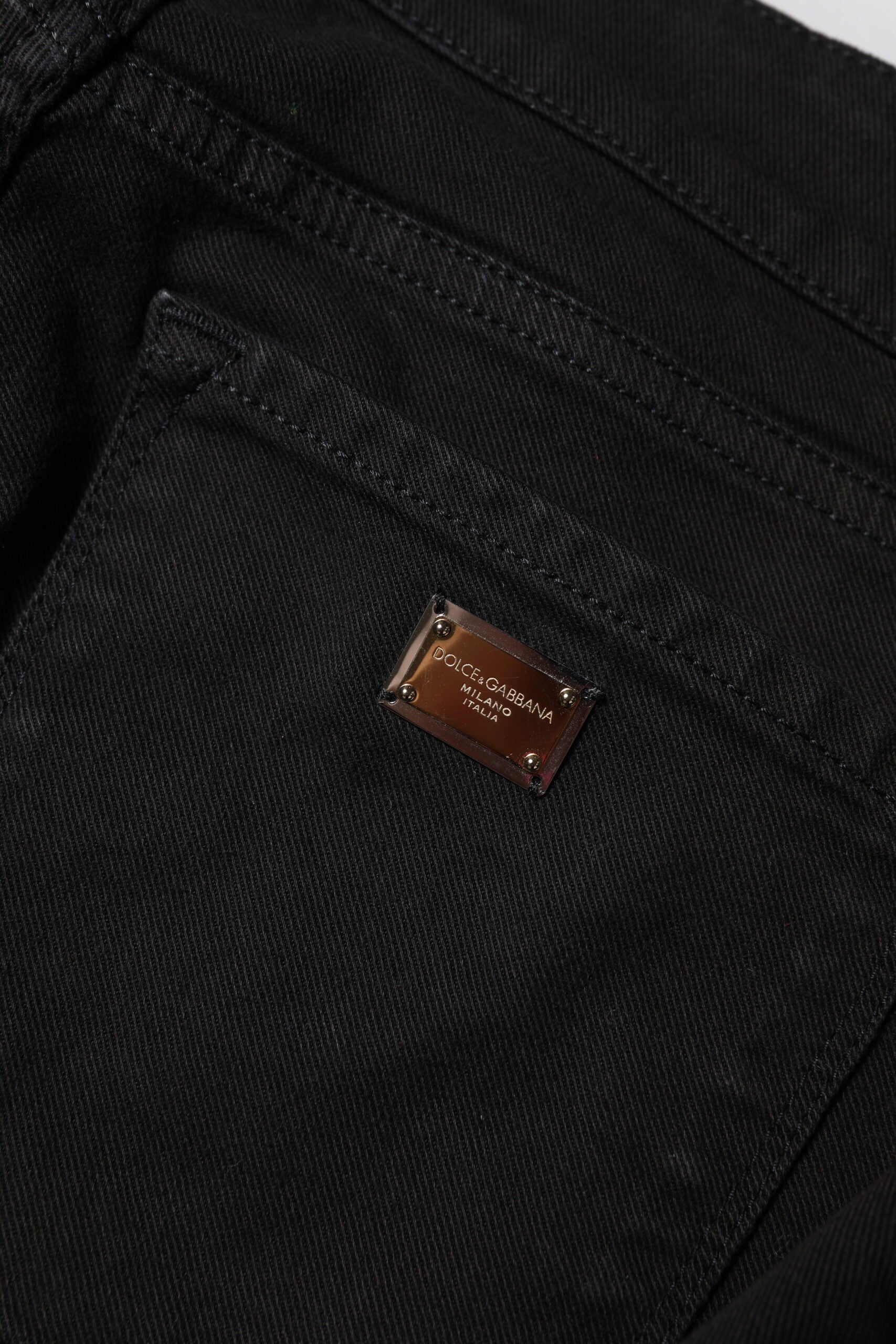 Indulge in the exquisite Dolce & Gabbana Black Cotton Logo Skinny Mid Waist Denim Jeans, where Italian craftsmanship meets timeless elegance, perfect for the discerning individual.