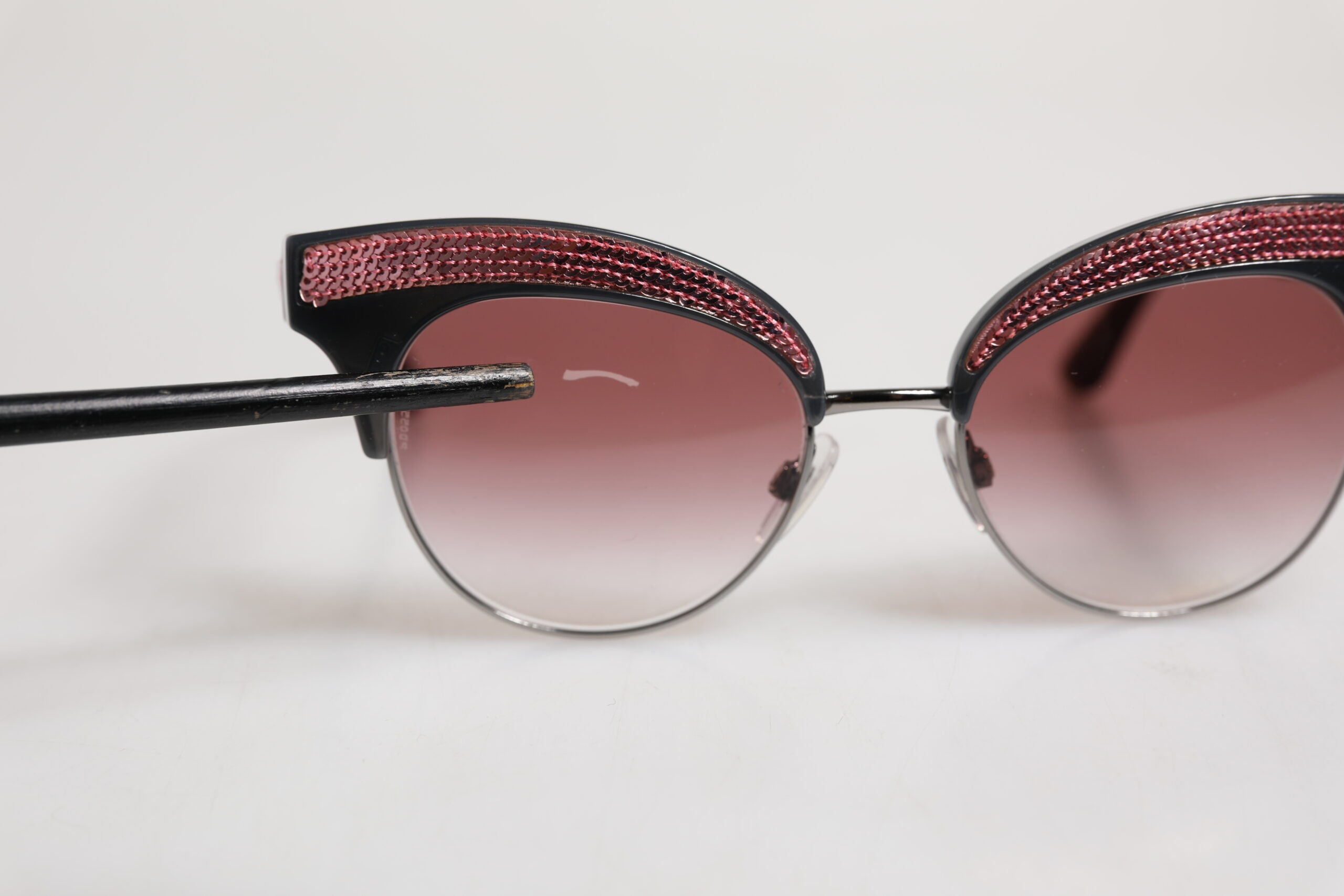 Indulge in the exquisite allure of Dolce & Gabbana's Black Pink Mirrored Cat Eye DG6109 Sequined Sunglasses, a statement of luxury and artistry for the discerning eye.