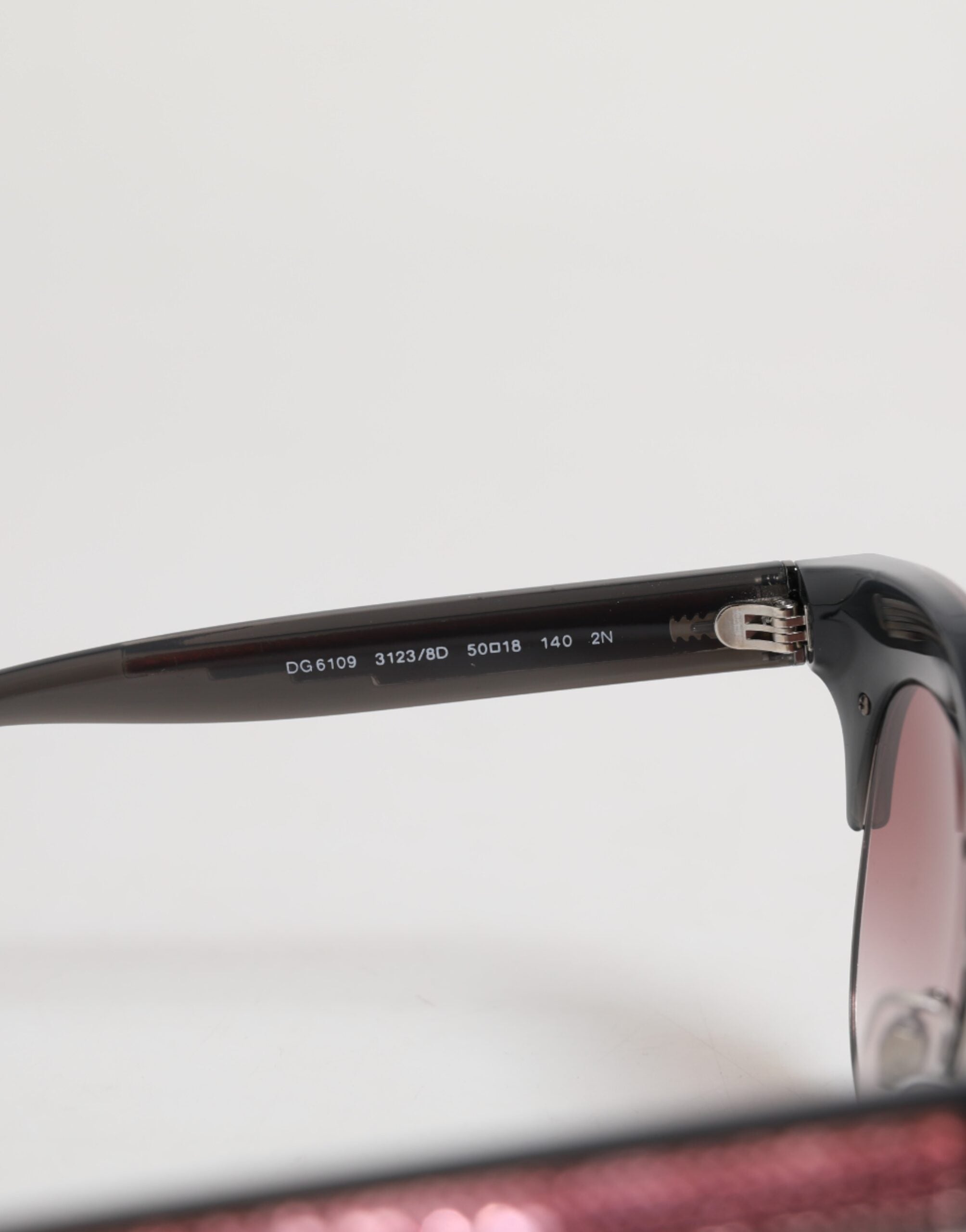Indulge in the exquisite Dolce & Gabbana Black Pink Mirrored Cat Eye DG6109 Sequined Sunglasses, where luxury craftsmanship meets timeless elegance, perfect for any occasion.