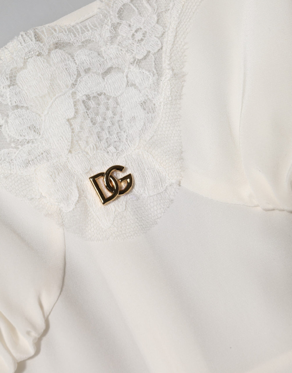 Indulge in the exquisite allure of Dolce & Gabbana's White Lace Gold DG Logo Silk Dress Sleepwear, a masterpiece of Italian craftsmanship that embodies luxury and sophistication.