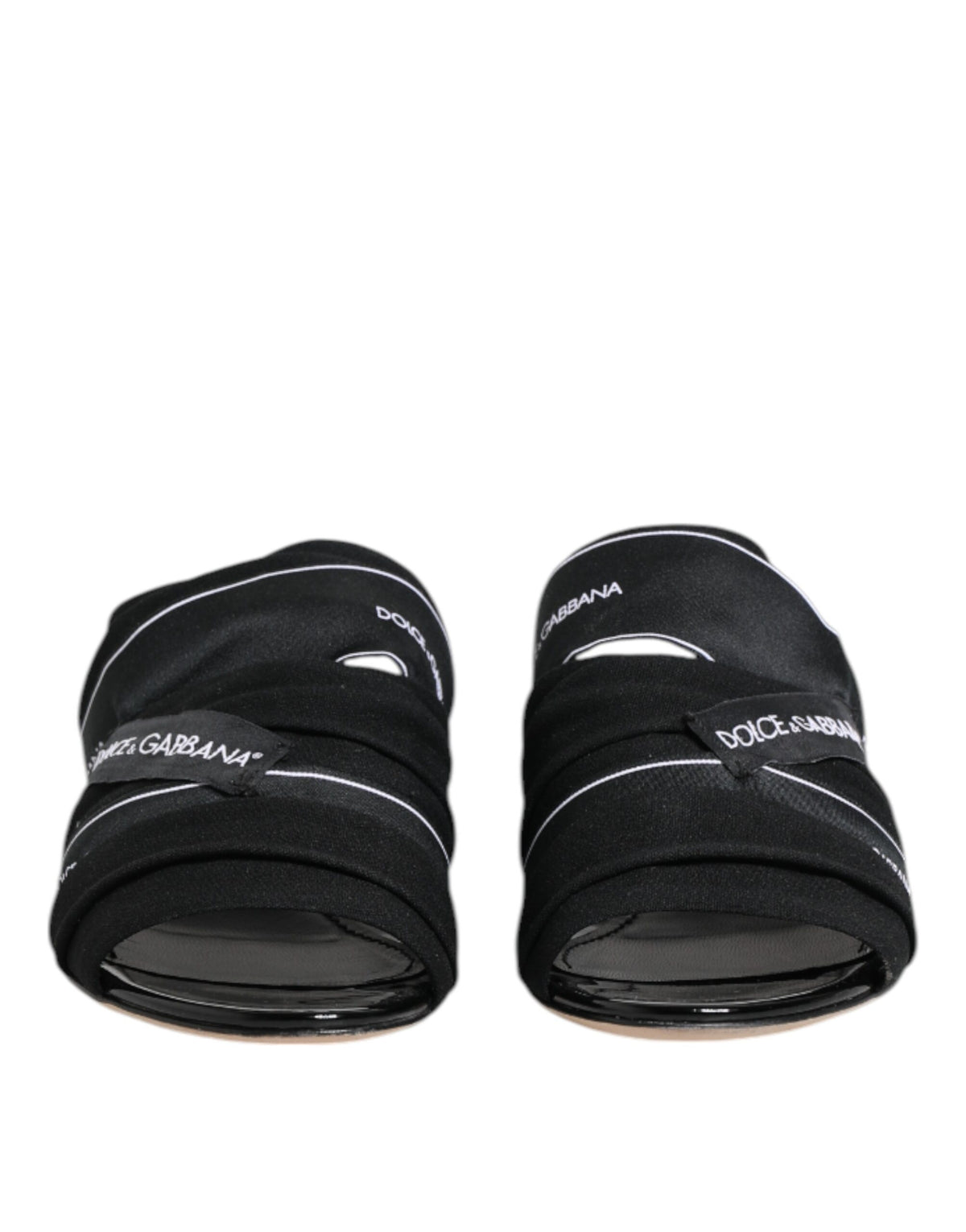 Indulge in the exquisite Dolce & Gabbana Black Slides, crafted from luxurious fabric and leather, embodying timeless elegance for those who appreciate refined sophistication.