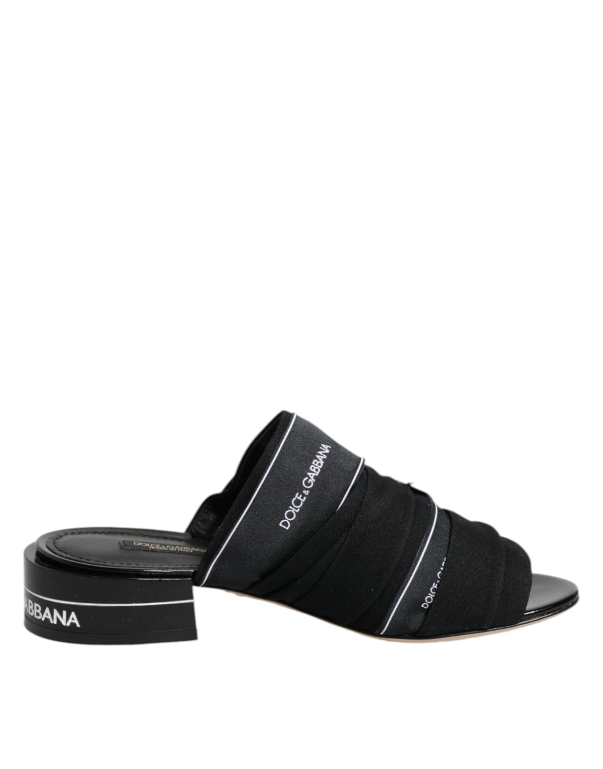 Indulge in the timeless elegance of Dolce & Gabbana Black Slides, crafted from luxurious fabric and leather, embodying sophistication for the discerning individual.