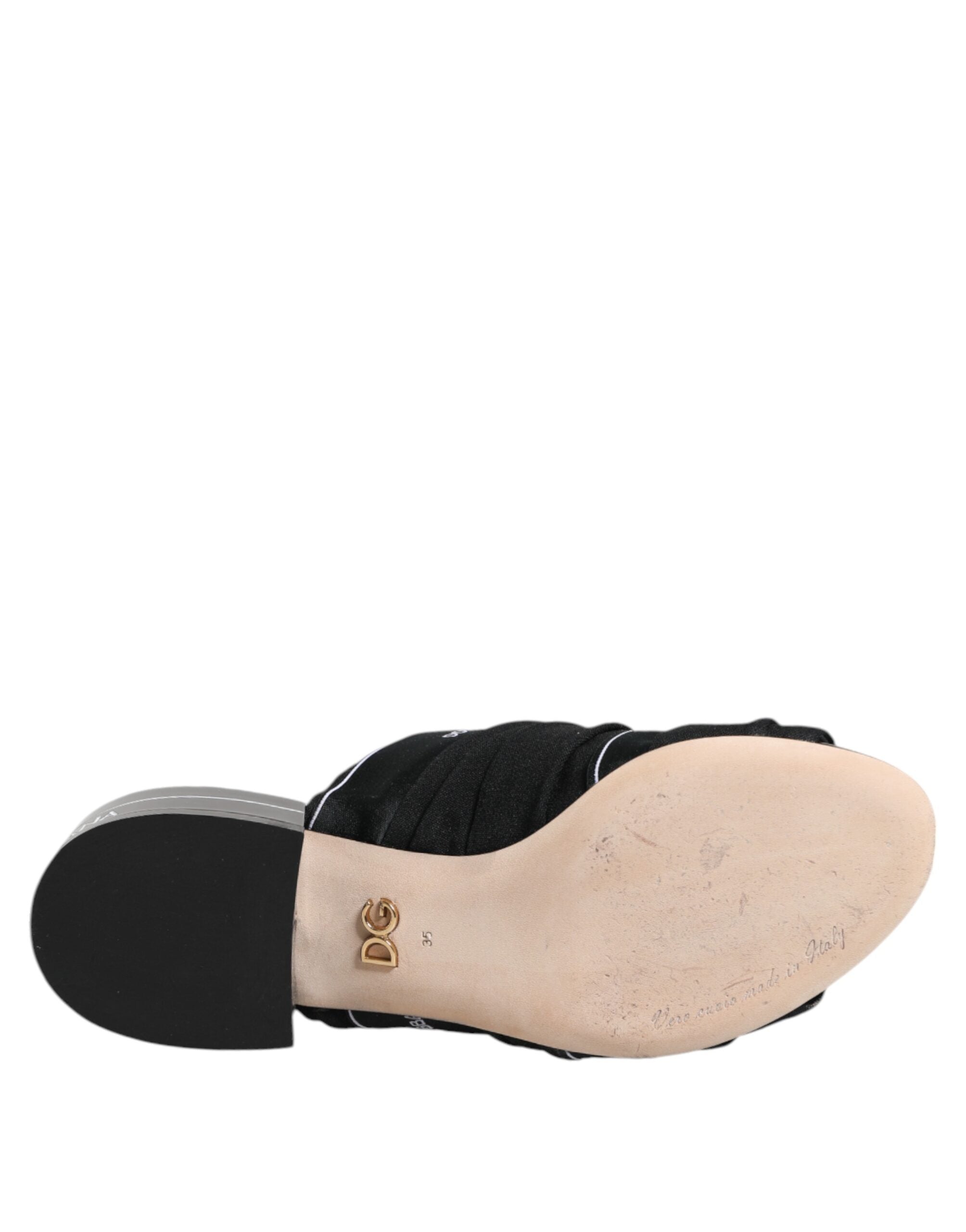Indulge in the exquisite Dolce & Gabbana Black Slides, crafted from premium fabric and leather, embodying timeless elegance for the discerning individual.