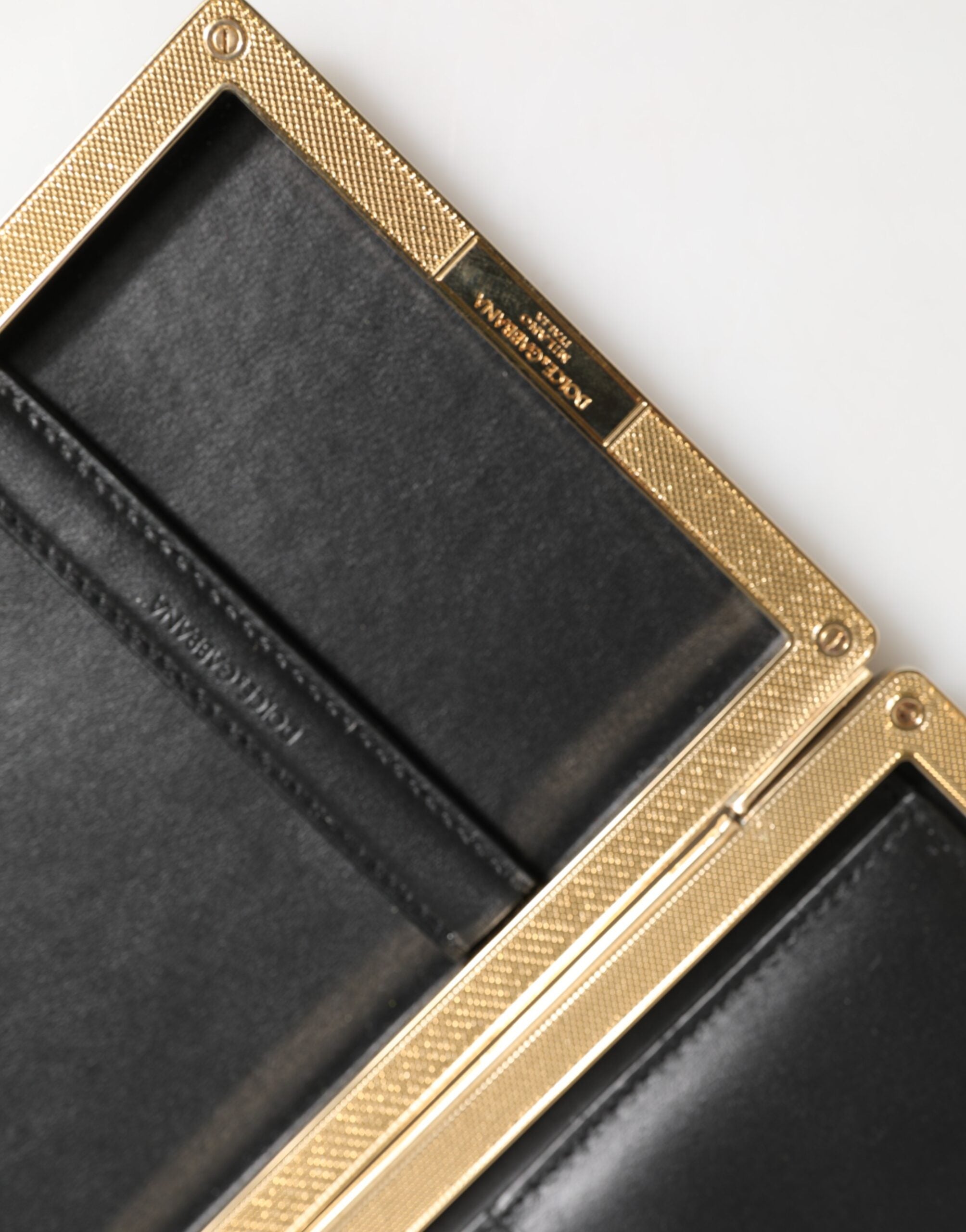 Elevate your evening allure with the Dolce & Gabbana Black Leather Gold Frame Clutch, a masterpiece of Italian craftsmanship in luxurious goat leather, perfect for discerning tastes.