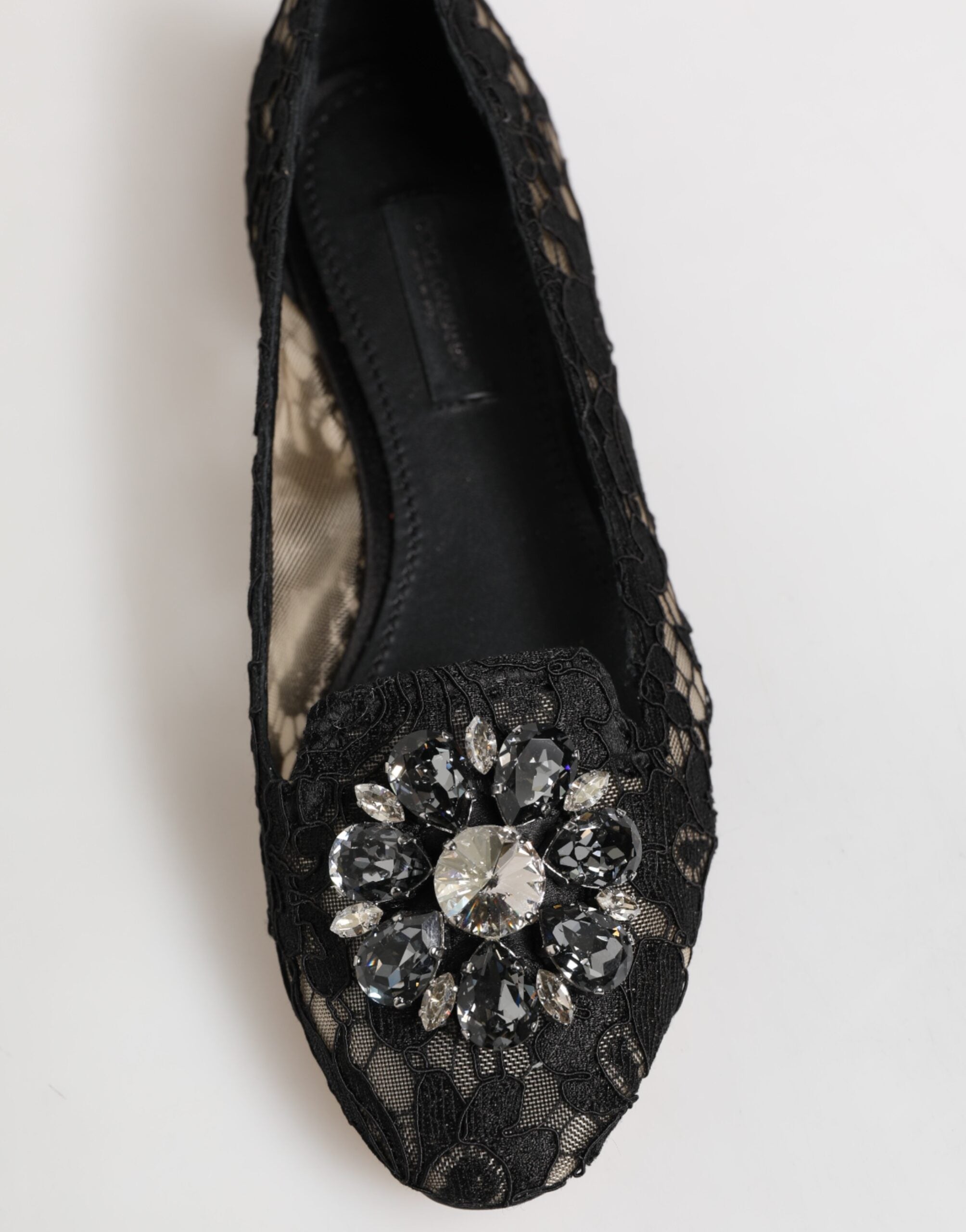 Step into the allure of Dolce & Gabbana's Black Taormina Lace Crystals Flats, where exquisite craftsmanship meets timeless elegance, perfect for the discerning individual.