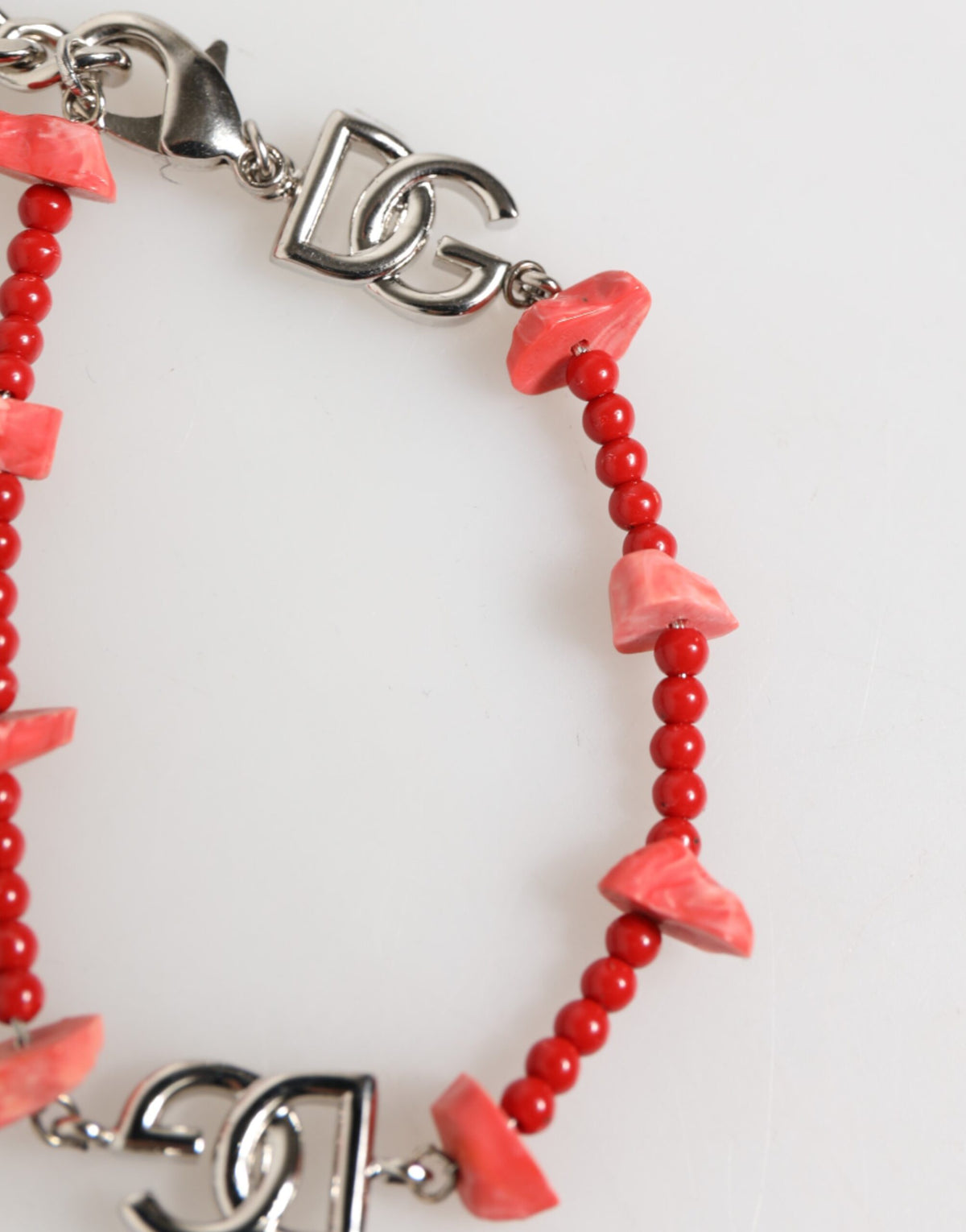 Discover the Dolce & Gabbana Silver Tone Brass Beaded Resin DG Logo Chain Bracelet, a masterpiece of Italian craftsmanship that embodies timeless elegance and sophistication.