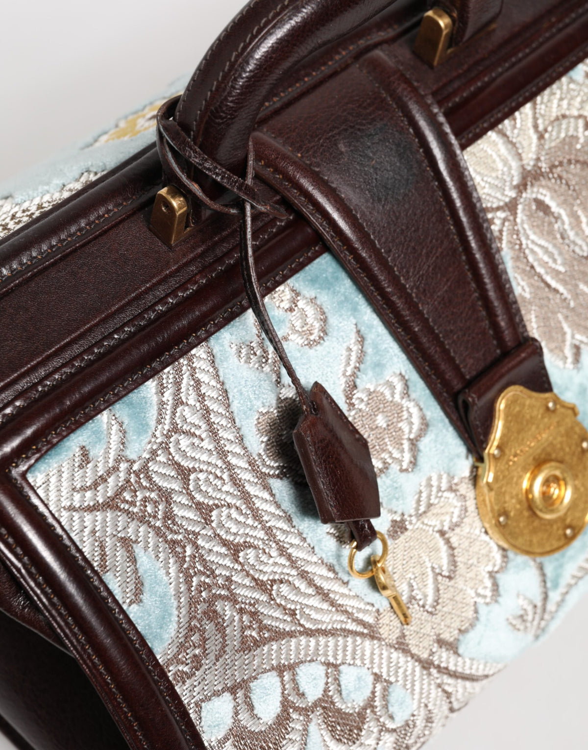 Elevate your style with the Dolce & Gabbana Blue Brown Leather Floral Jacquard Travel Handbag, a masterpiece of premium leather and velvet, embodying timeless luxury and sophistication.