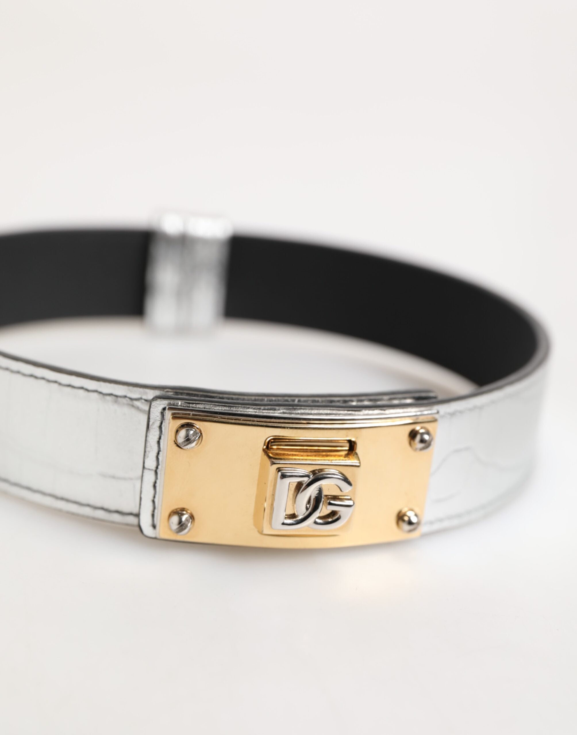 Indulge in the exquisite Dolce & Gabbana Silver Textured Leather Gold Tone Metal Neckband, a statement of modern elegance that embodies timeless luxury and artisanal craftsmanship.