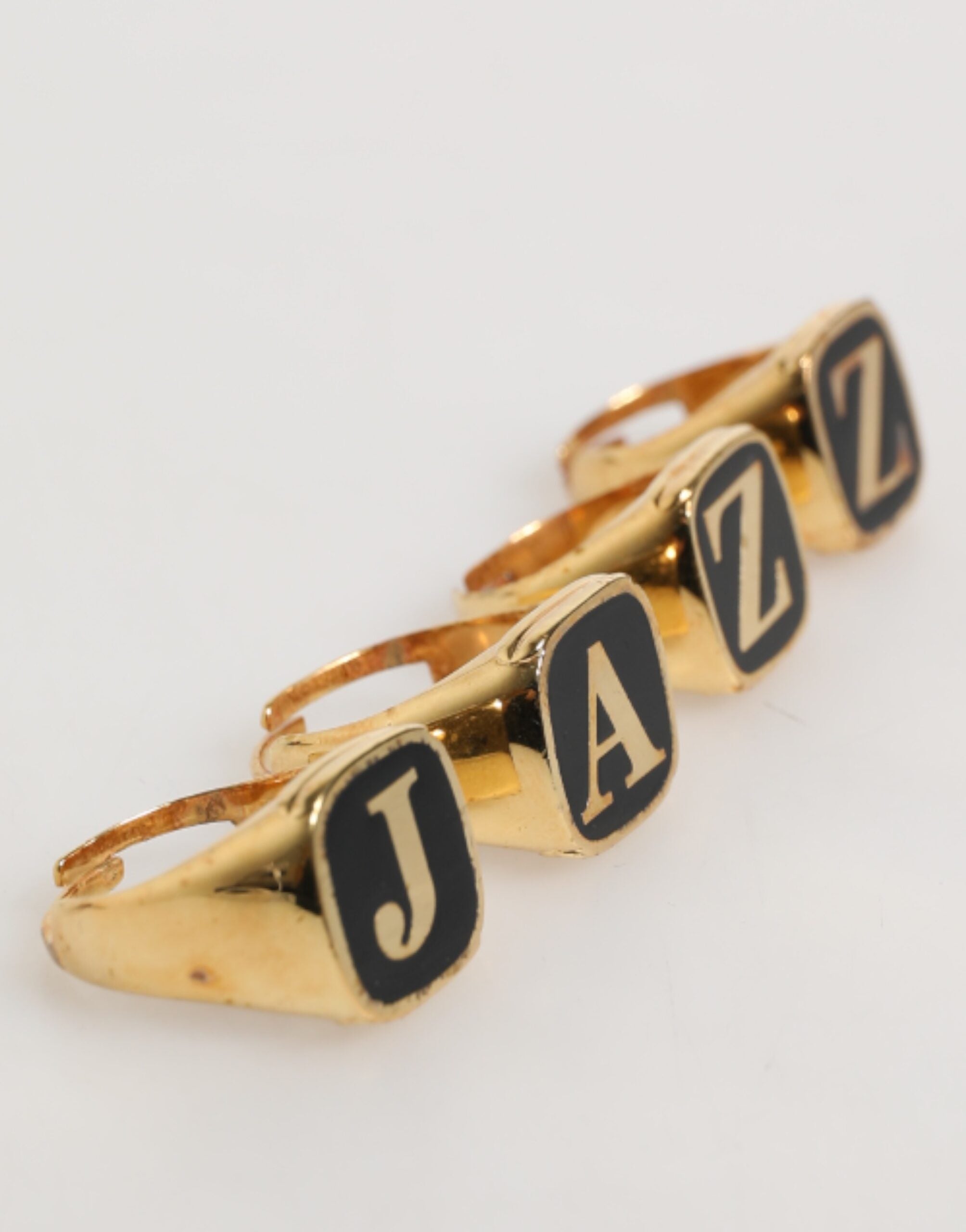 Elevate your style with the Dolce & Gabbana Gold Tone Brass JAZZ Letter Set, a luxurious fusion of silver and enamel, embodying artistry and sophistication.