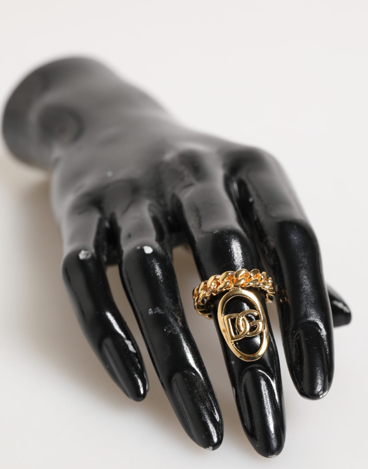 Indulge in the exquisite Dolce & Gabbana Gold Tone Brass Oval DG Logo Chain Adjustable Ring, a statement of elegance and sophistication that transcends time.