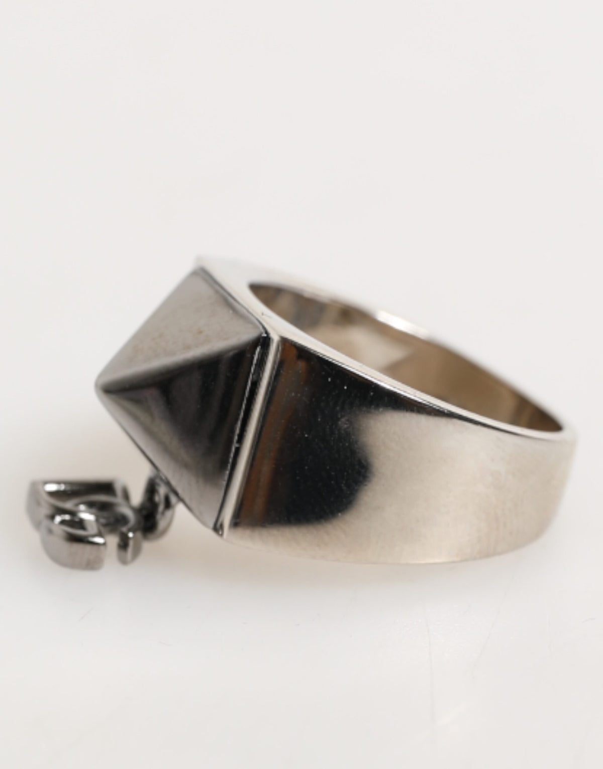 Indulge in the exquisite allure of the Dolce & Gabbana Silver Tone Pyramid DG Logo Real Brass Ring, a timeless statement of Italian craftsmanship and modern elegance.