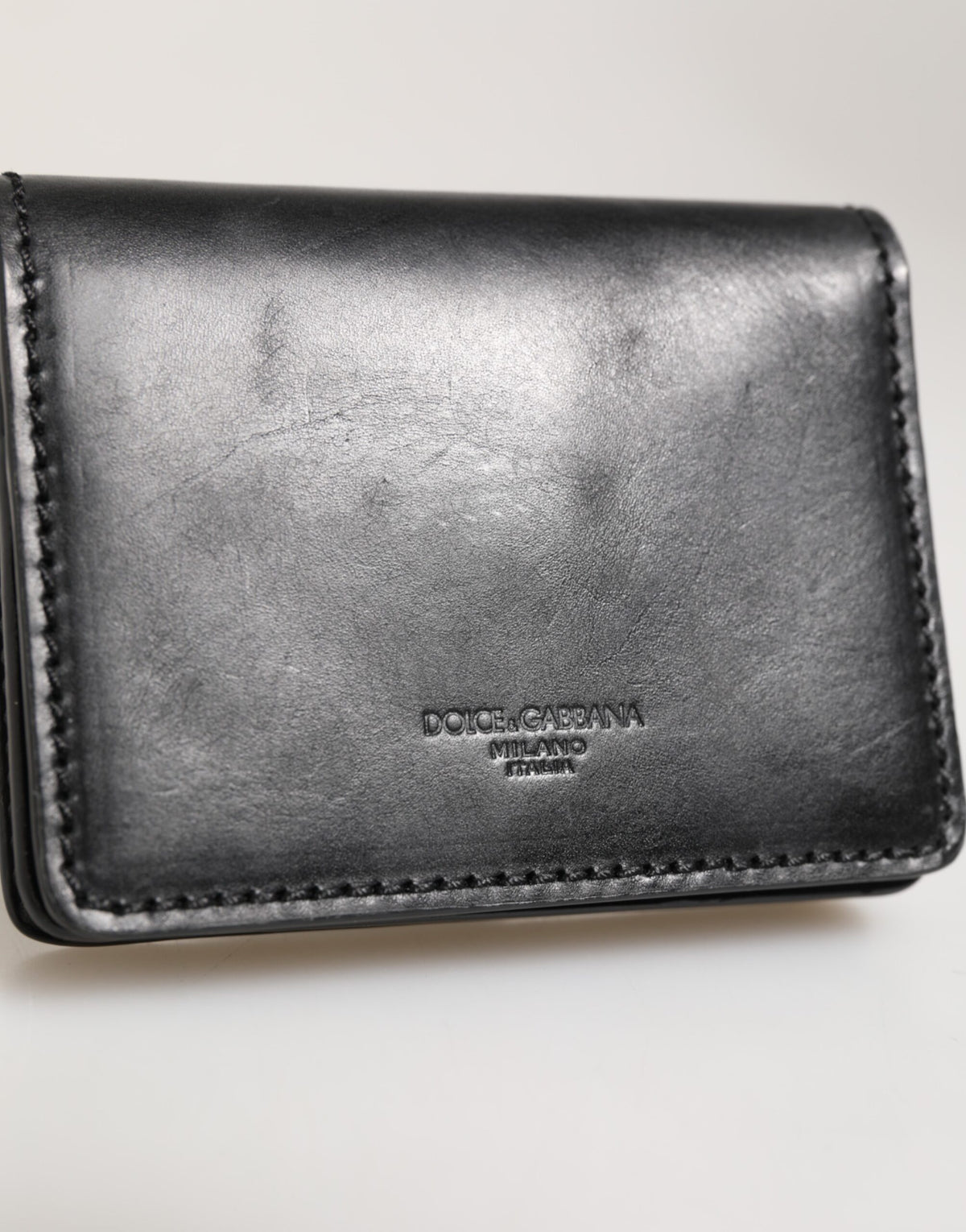 Experience the allure of Dolce & Gabbana's Black Leather Bifold Card Holder, a masterful blend of premium craftsmanship and timeless elegance, perfect for the discerning individual.