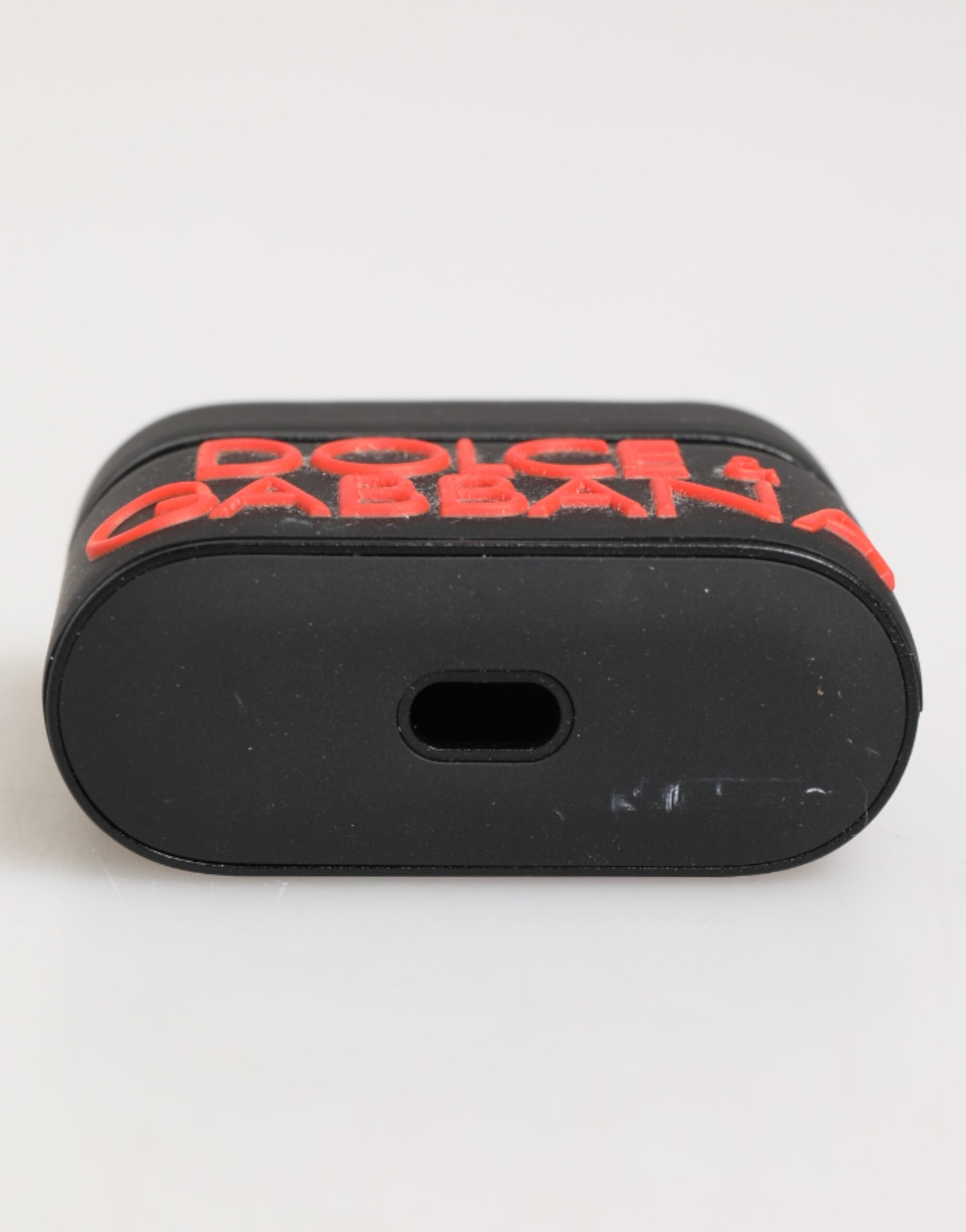 Elevate your accessory game with the Dolce & Gabbana Black Orange Rubber Airpods Case, a blend of exquisite craftsmanship and bold design, perfect for the discerning individual.