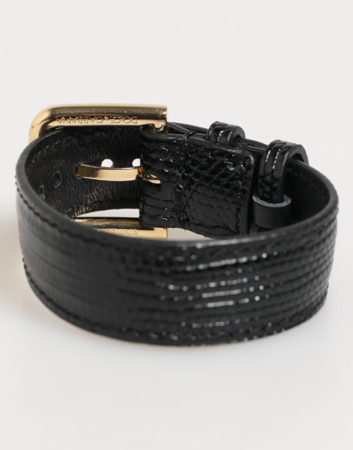Indulge in the exquisite Dolce & Gabbana Black Embossed Leather Gold Buckle Belt Strap Bracelet, a testament to Italian craftsmanship and timeless elegance, perfect for the discerning individual.