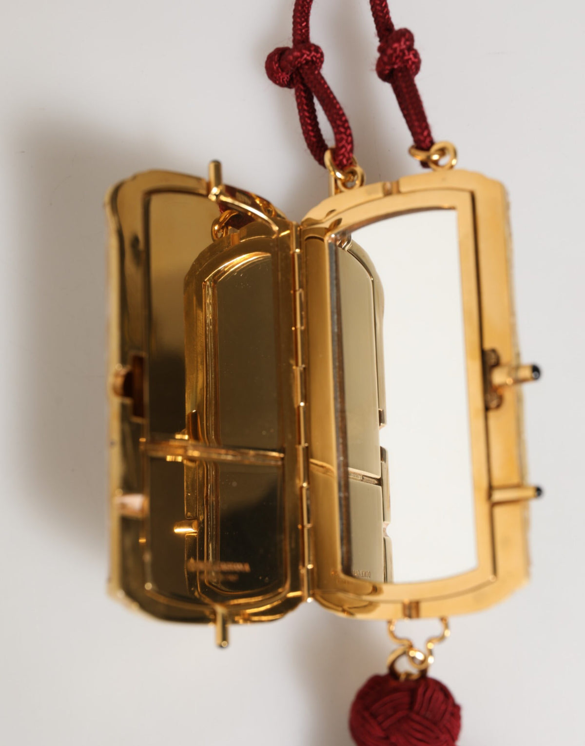 Indulge in the exquisite Dolce & Gabbana White Pearl Resin Gold Metal Red Tassel Pendant Bag, a timeless symbol of luxury and sophistication, perfect for elevating any ensemble.