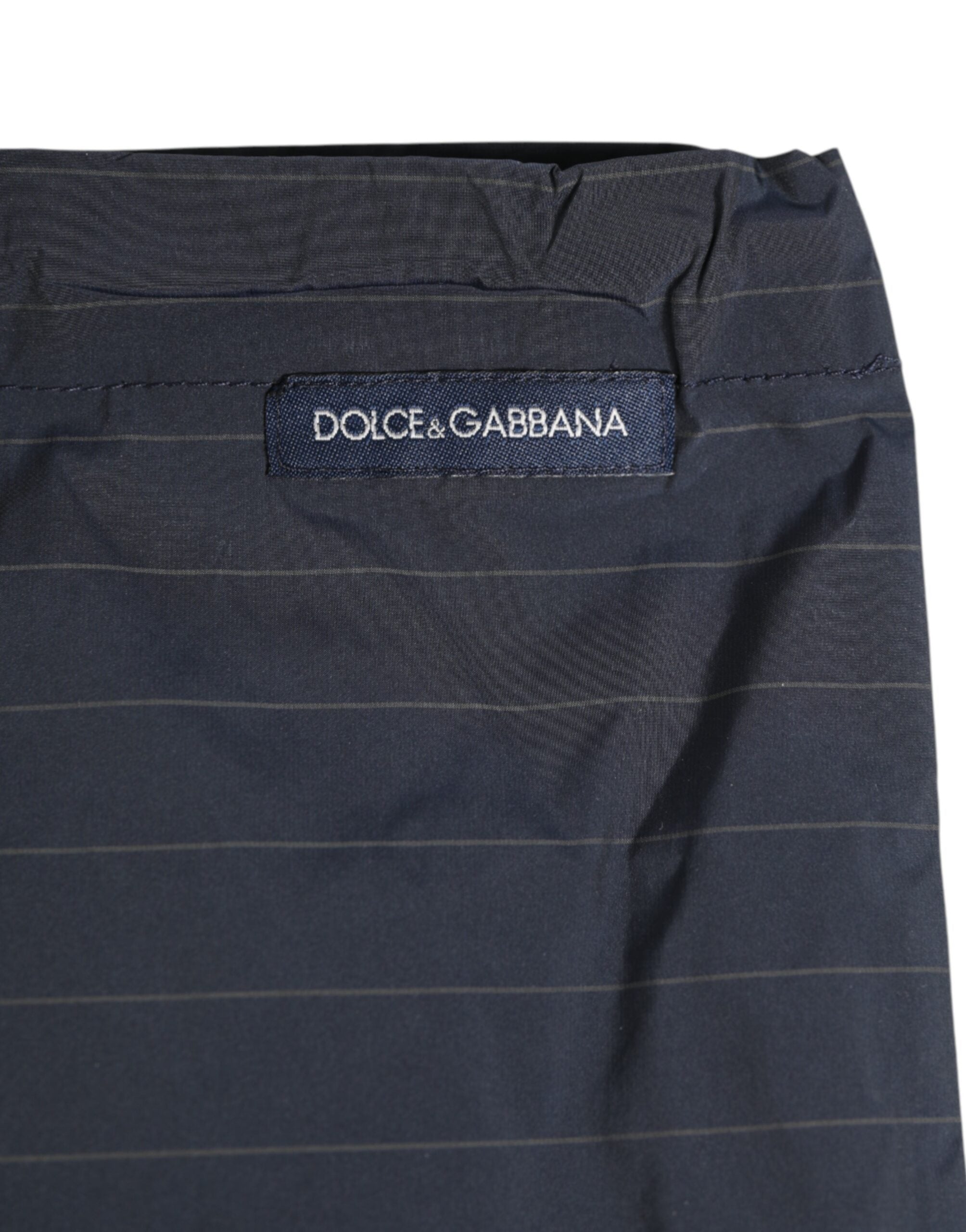 Experience the allure of Dolce & Gabbana's navy blue pinstripe swim shorts, crafted from premium materials for an elegant blend of sophistication and comfort.