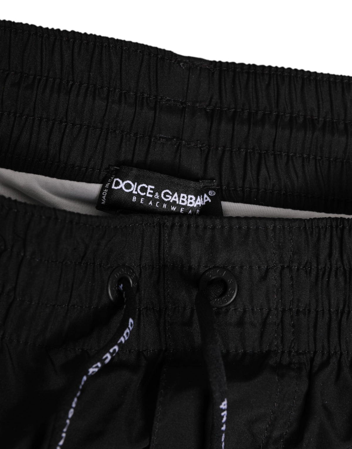Elevate your beachwear collection with Dolce & Gabbana's luxurious black and white striped swim shorts, crafted for the discerning individual who embodies elegance and confidence.