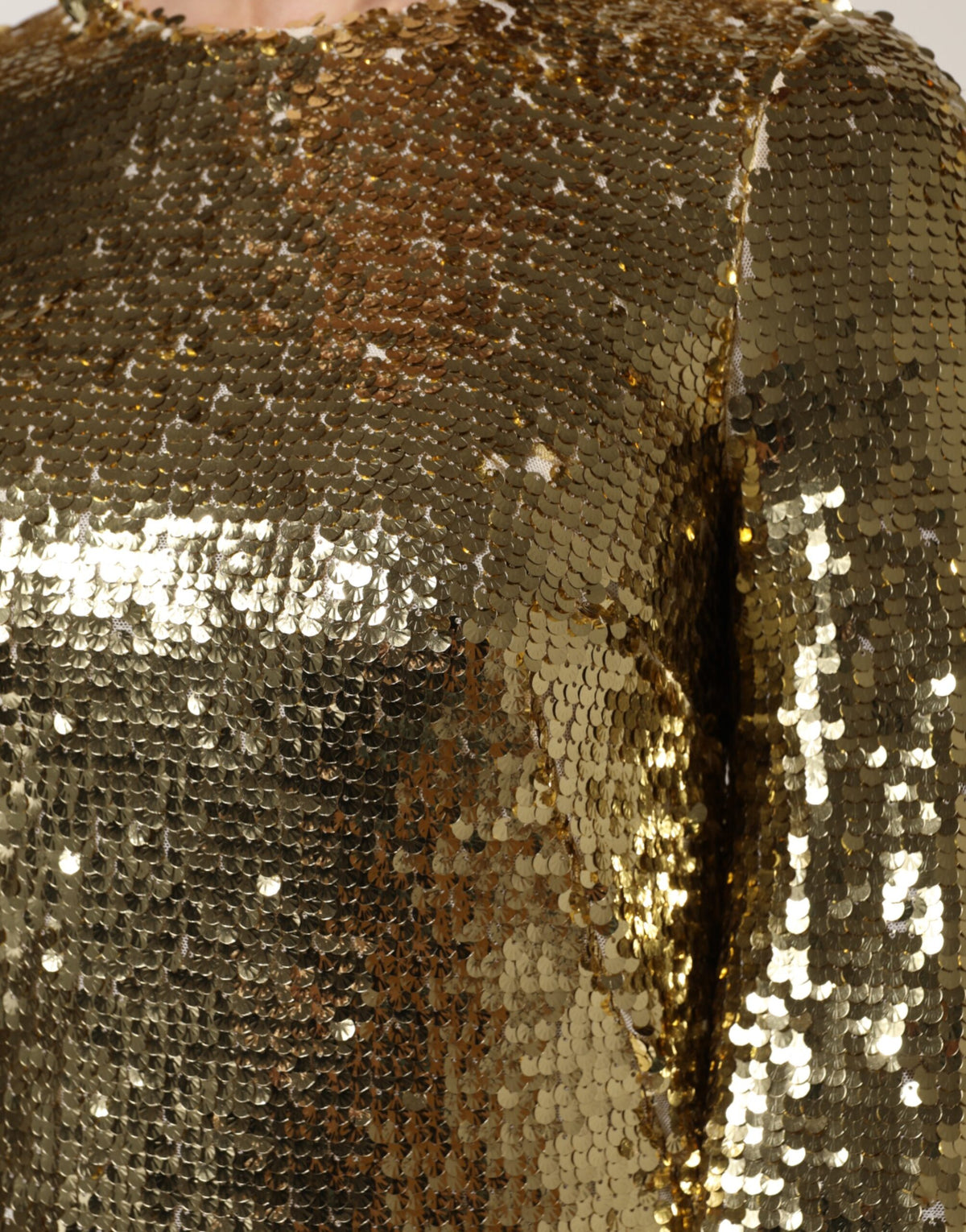 Indulge in the opulence of the Dolce & Gabbana Gold Sequin Long Sleeve Mini Dress, where exquisite craftsmanship meets luxurious silk lining for an unforgettable statement.