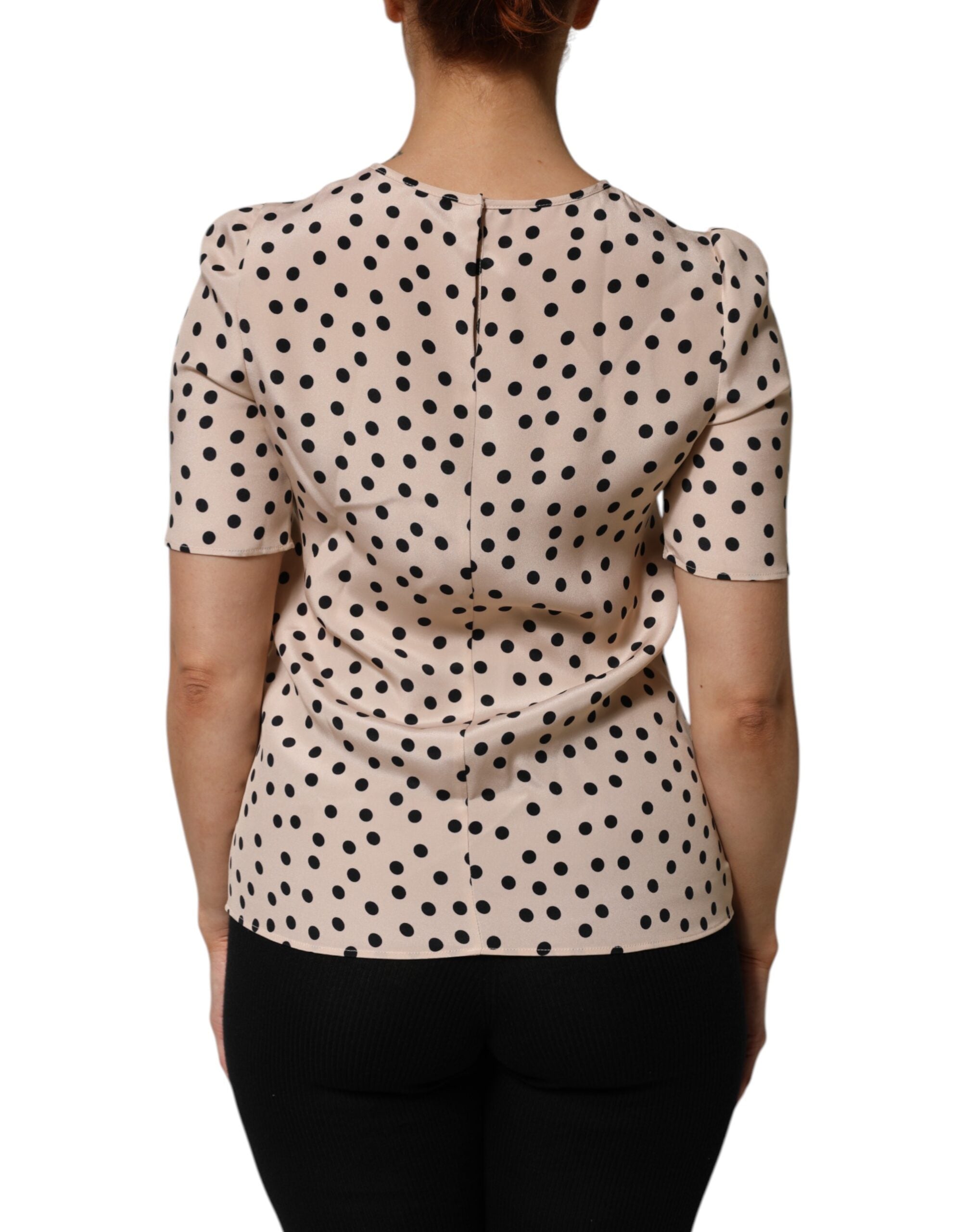 Indulge in the exquisite Dolce & Gabbana Beige Black Polka Dot Silk Short Sleeve Blouse, a masterpiece of Italian craftsmanship that embodies timeless elegance and playful sophistication.