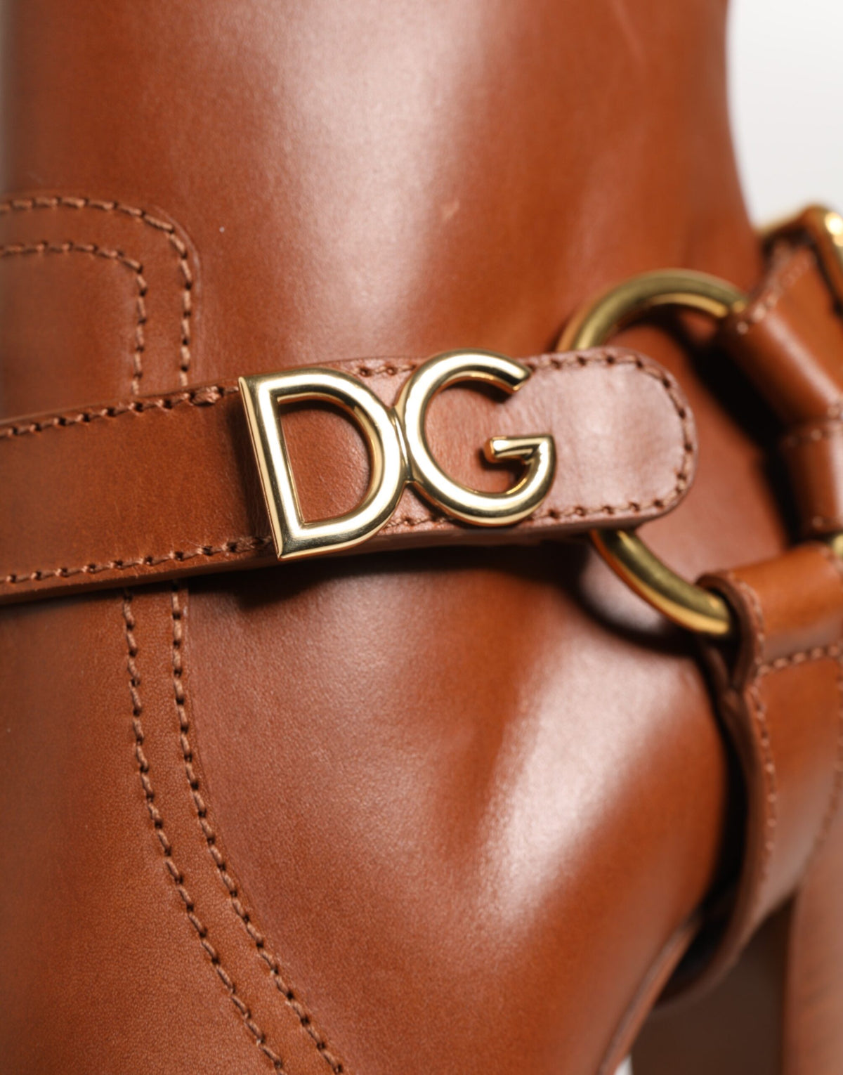 Indulge in the exquisite Dolce & Gabbana Brown Leather DG Logo Buckle Ankle Boots, crafted from luxurious calf leather, embodying sophistication and timeless elegance for the discerning individual.