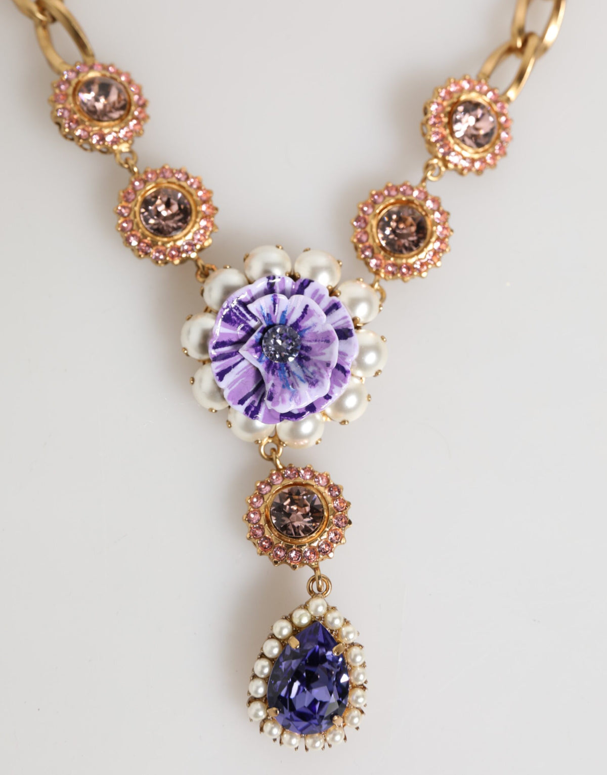 Indulge in the exquisite allure of Dolce & Gabbana's Gold Brass Crystal Pearl Purple Floral Pendant Necklace, a luxurious statement piece that embodies elegance and artistry.
