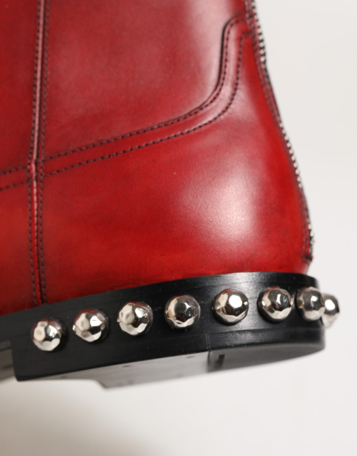 Indulge in the exquisite Dolce & Gabbana Red Studded Chelsea Ankle Boots, crafted from luxurious calf leather, embodying bold elegance and timeless sophistication.