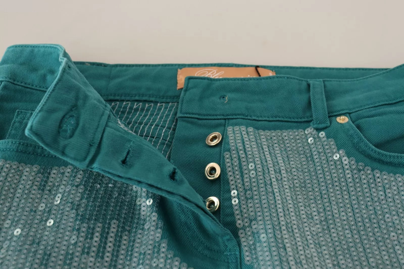 Discover the allure of Blumarine's Cadet Blue Sequined Low Waist Cropped Trouser Pants, a masterpiece of Italian craftsmanship that elevates your style with luxurious sophistication.