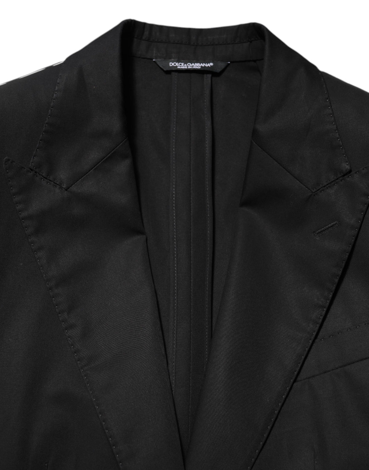 Elevate your wardrobe with the Dolce & Gabbana Black Wool 2 Buttons Suit Men Jacket Blazer, a masterpiece of Italian craftsmanship that embodies timeless elegance and sophisticated allure.