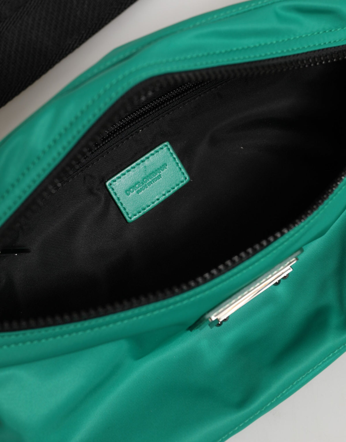 Discover the Dolce & Gabbana Green Logo Plaque Nylon Fanny Pack, a luxurious blend of nylon and calfskin, embodying sophistication and timeless elegance for the discerning individual.