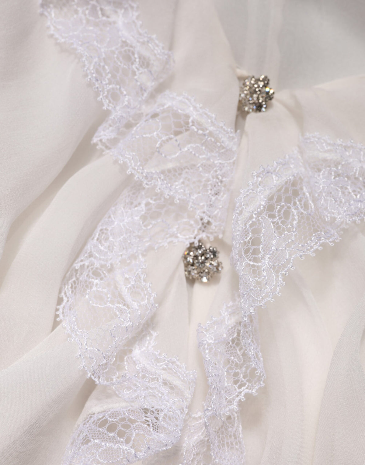 Indulge in the exquisite Dolce & Gabbana White Ruffles Lace Long Sleeve Blouse, crafted from a luxurious silk blend, embodying timeless elegance and refined sophistication.