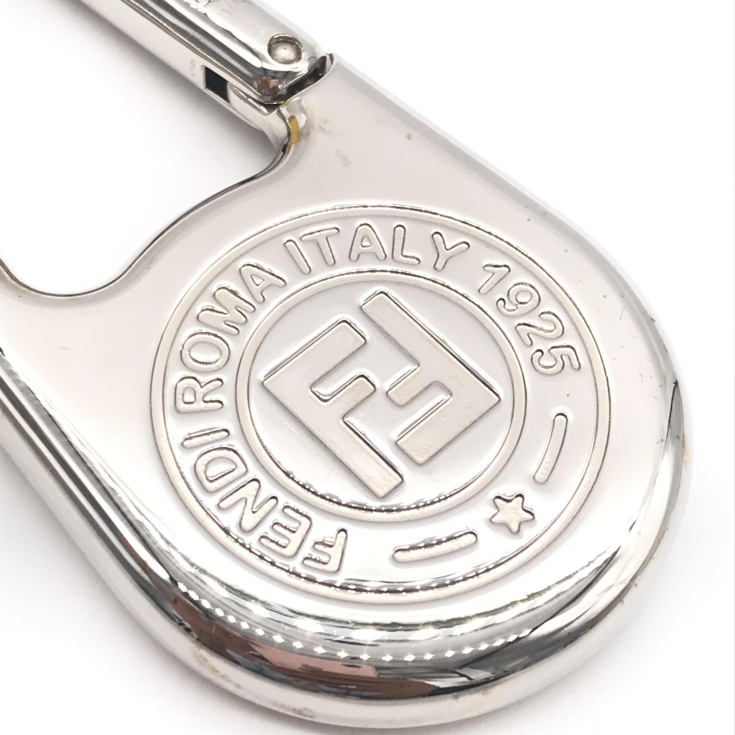 Elevate your style with the Fendi Silver Metal Compass Charm Keychain, a symbol of exquisite craftsmanship and timeless elegance, perfect for life's sophisticated journeys.