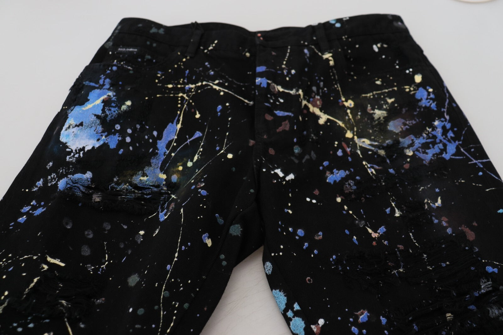 Indulge in the exquisite artistry of Dolce & Gabbana's Black Cotton Color Splash Print Denim Jeans, where bold elegance meets timeless luxury for a captivating wardrobe essential.