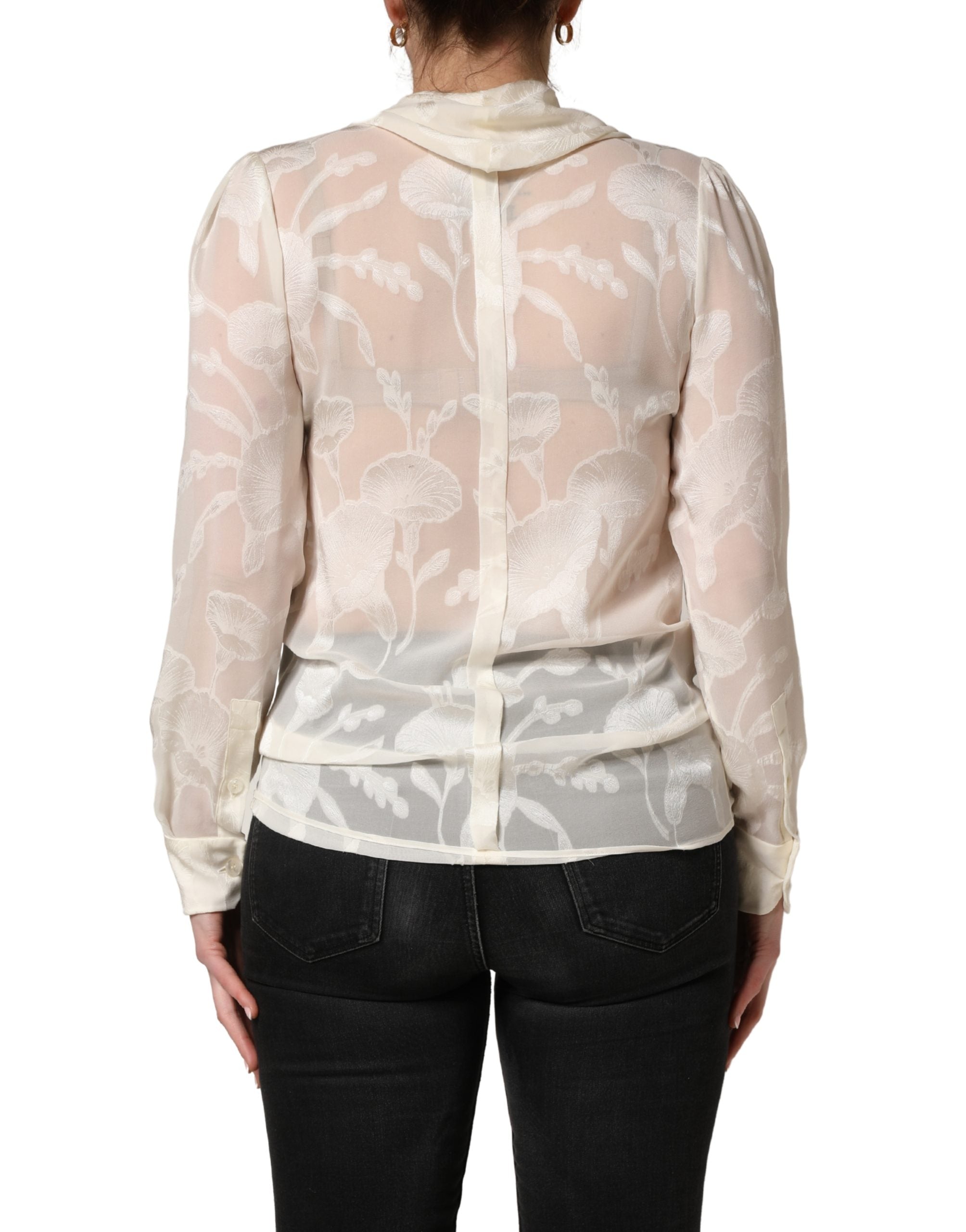 Elevate your wardrobe with the Dolce & Gabbana Off White Floral Semi Sheer Silk Blouse, a masterpiece of Italian craftsmanship that embodies timeless elegance and sophistication.