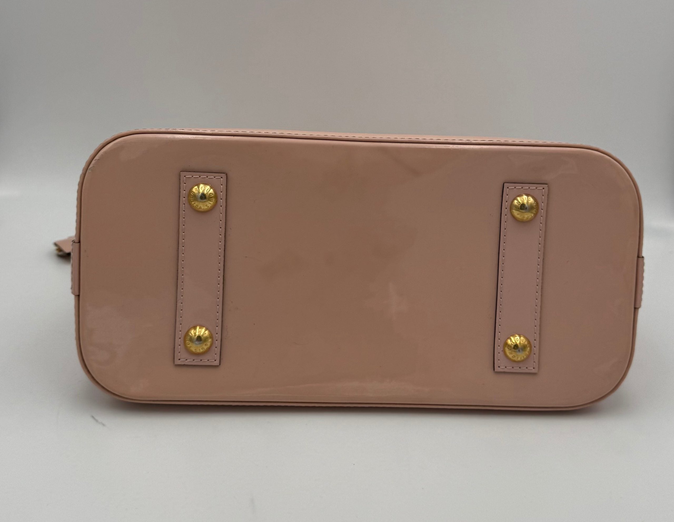 Indulge in the iconic Louis Vuitton Alma MM Pink Patent Monogram Handbag, a timeless masterpiece that embodies exquisite craftsmanship and luxurious allure.