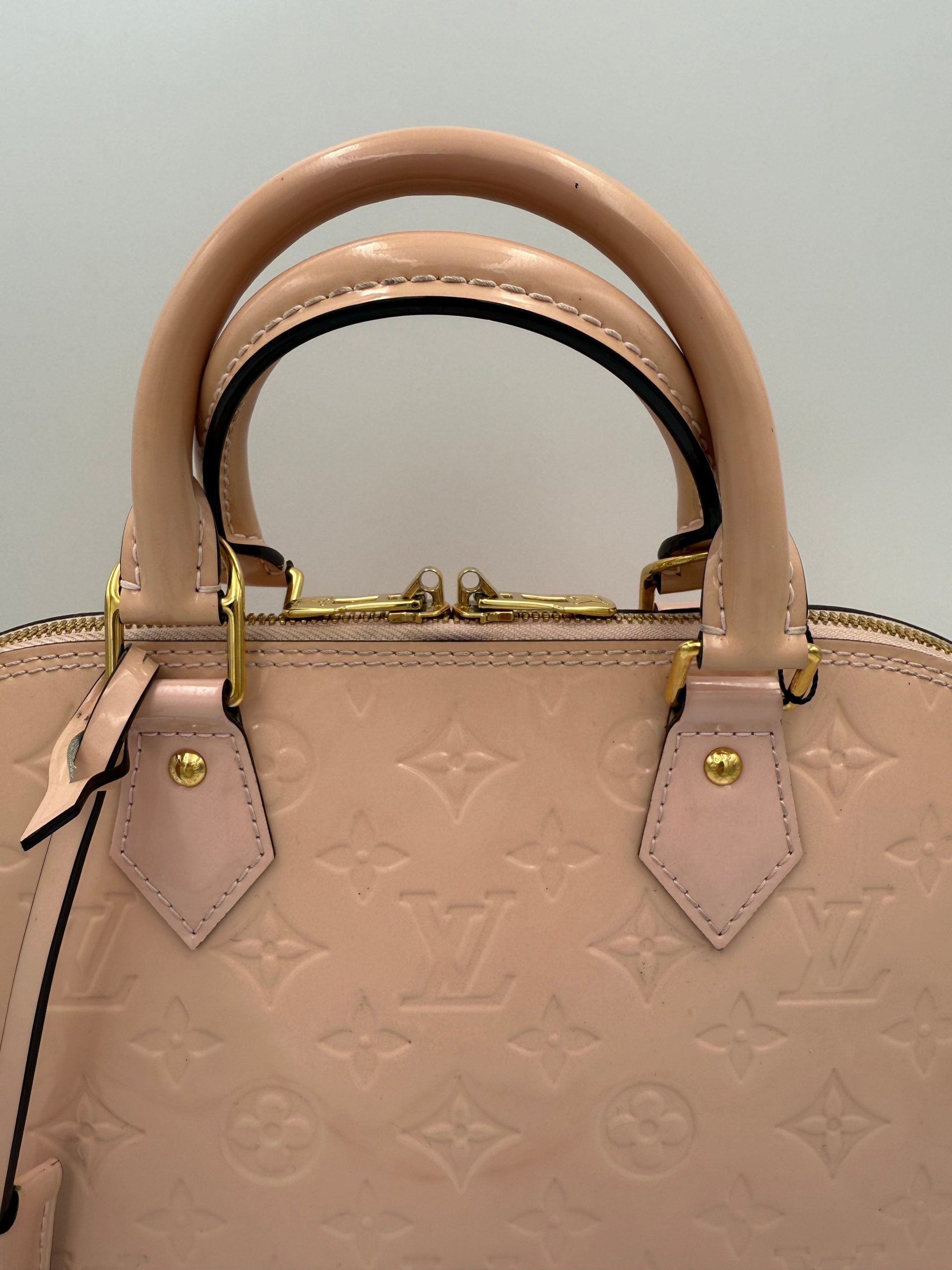 Indulge in the exquisite allure of the Louis Vuitton Alma MM Pink Patent Monogram Handbag, a timeless masterpiece that embodies luxury and iconic craftsmanship for discerning tastes.