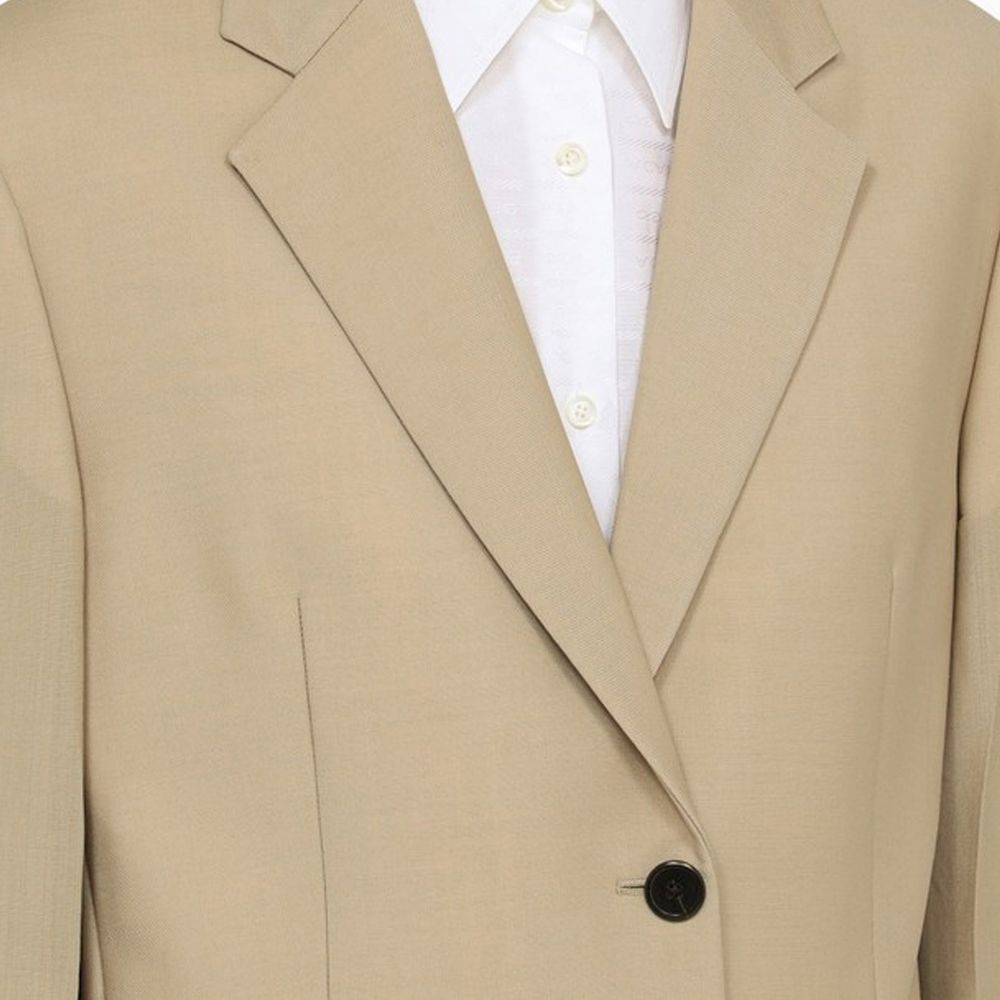 Elevate your wardrobe with the Prada Beige Mohair Blazer, a masterpiece of luxury crafted from fine mohair and virgin wool, embodying timeless elegance and sophistication.