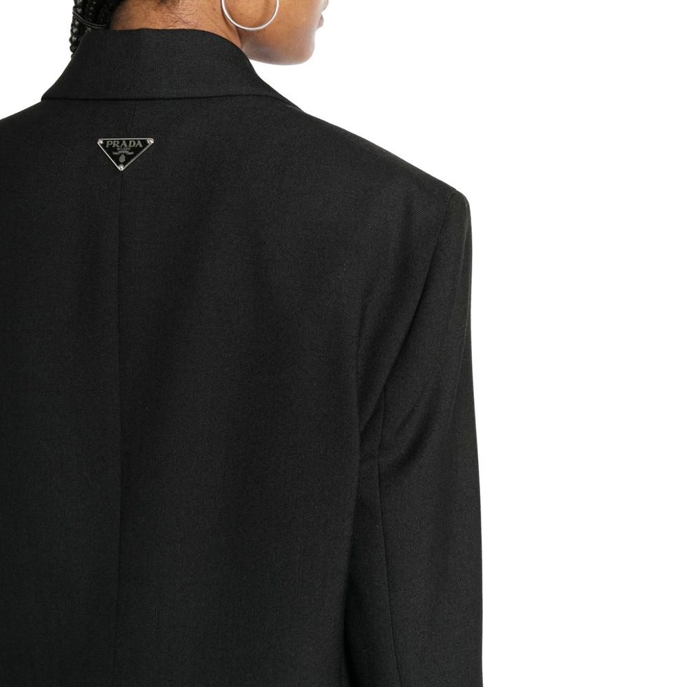 Elevate your wardrobe with the Prada Black Virgin Wool Blazer, a masterpiece of Italian craftsmanship, blending timeless elegance with luxurious comfort for the discerning individual.