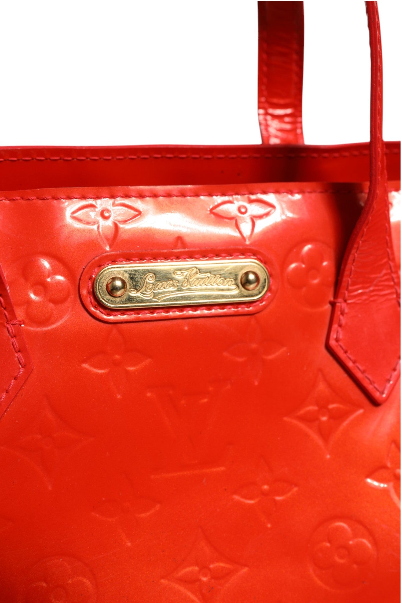 Experience the allure of the Louis Vuitton Red Monogram Vernis Wilshire PM, a masterpiece of exquisite craftsmanship that elevates your style with timeless elegance.