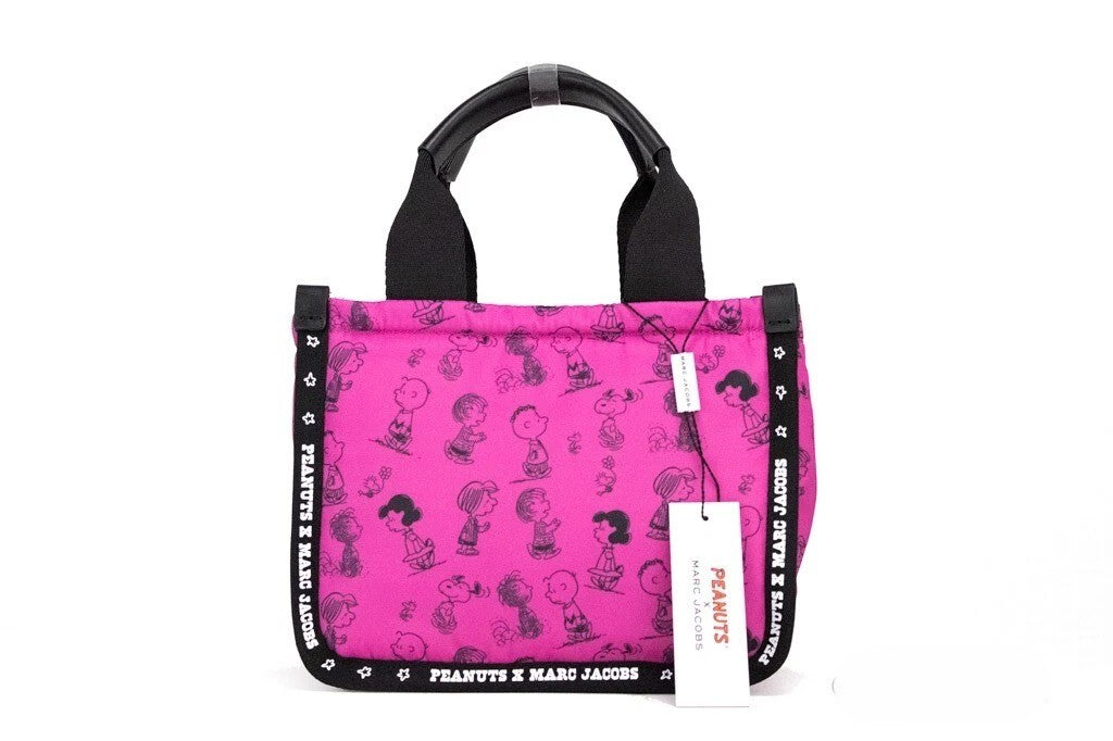 Elevate your style with the Marc Jacobs X Peanuts Mini Fuchsia Fedora Tote, a limited edition masterpiece in durable nylon, blending playful charm with exquisite craftsmanship.
