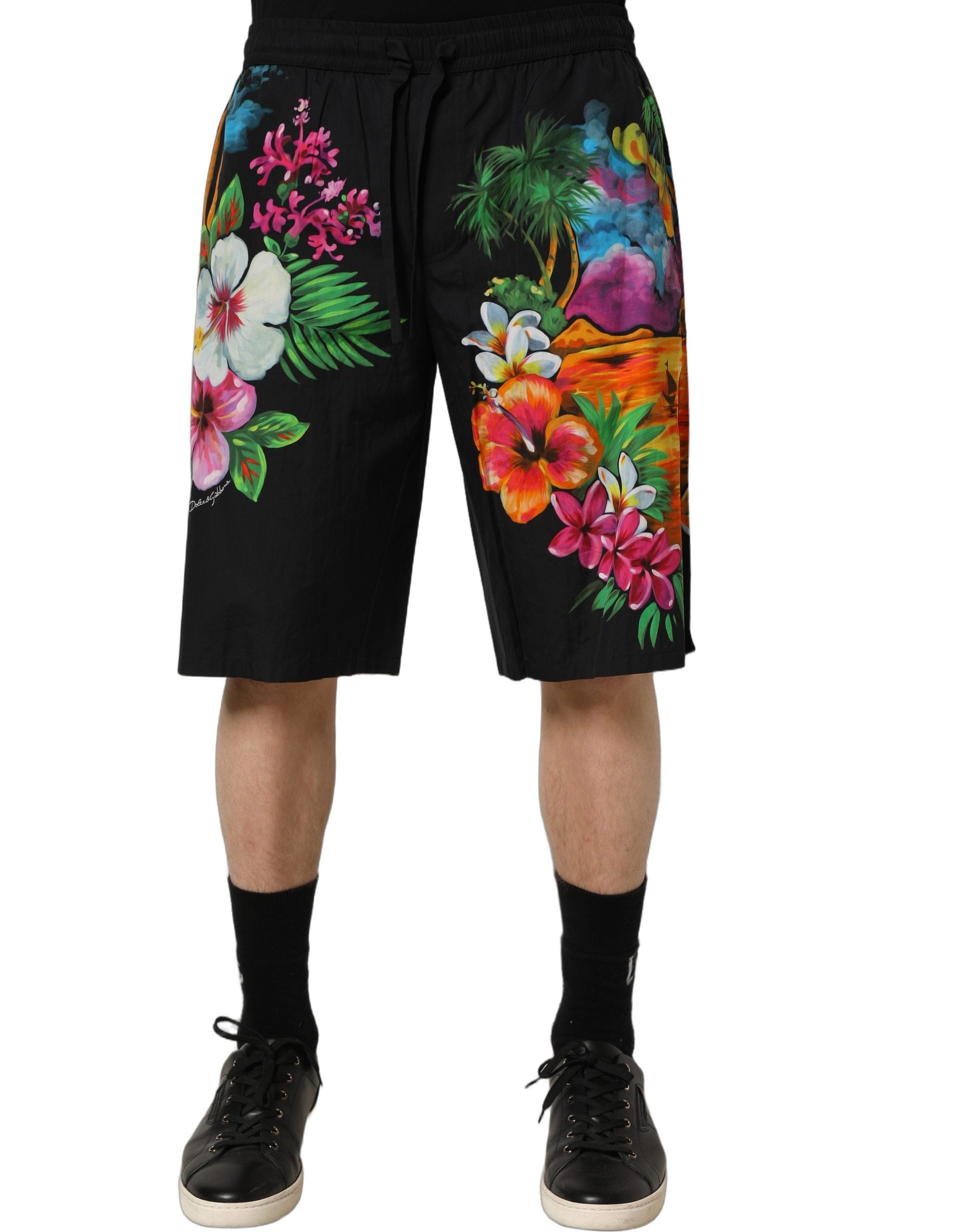 Elevate your summer style with Dolce & Gabbana's Black Cotton Tropical Floral Bermuda Shorts, a luxurious blend of comfort and vibrant elegance, crafted in Italy.