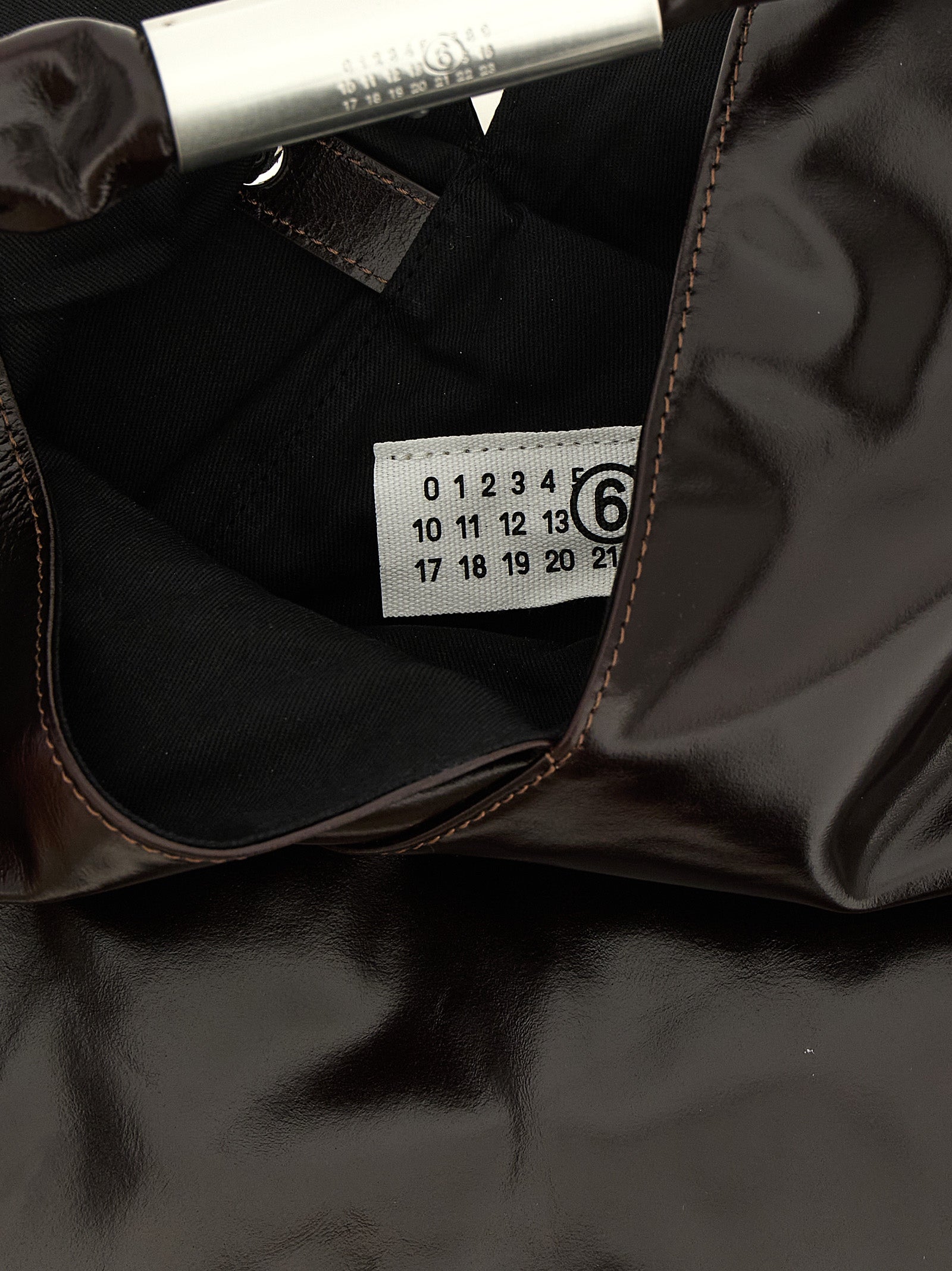 Indulge in the exquisite MM6 Maison Margiela Brown Cowhide Handbag, a masterpiece of artisanal craftsmanship and luxurious semi-gloss leather, perfect for the discerning.