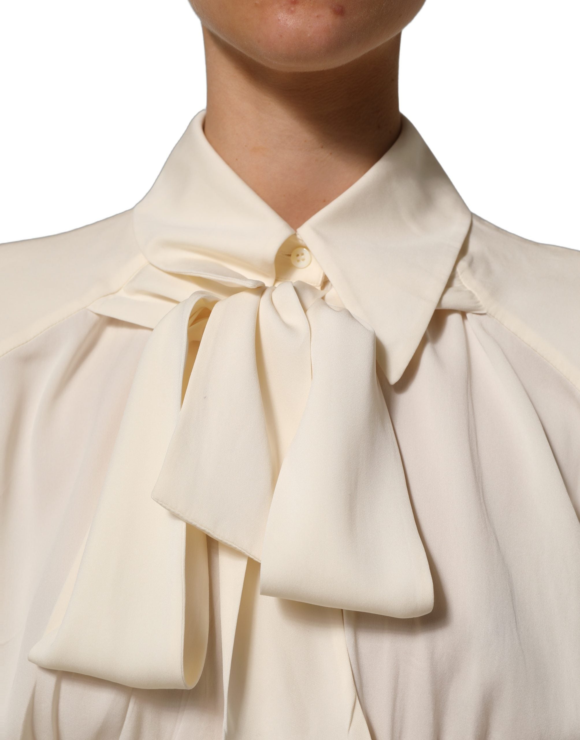 Discover the Dolce & Gabbana Off White Ascot Collar Blouse, a masterpiece of silk and elastane, embodying timeless elegance and exquisite Italian craftsmanship.
