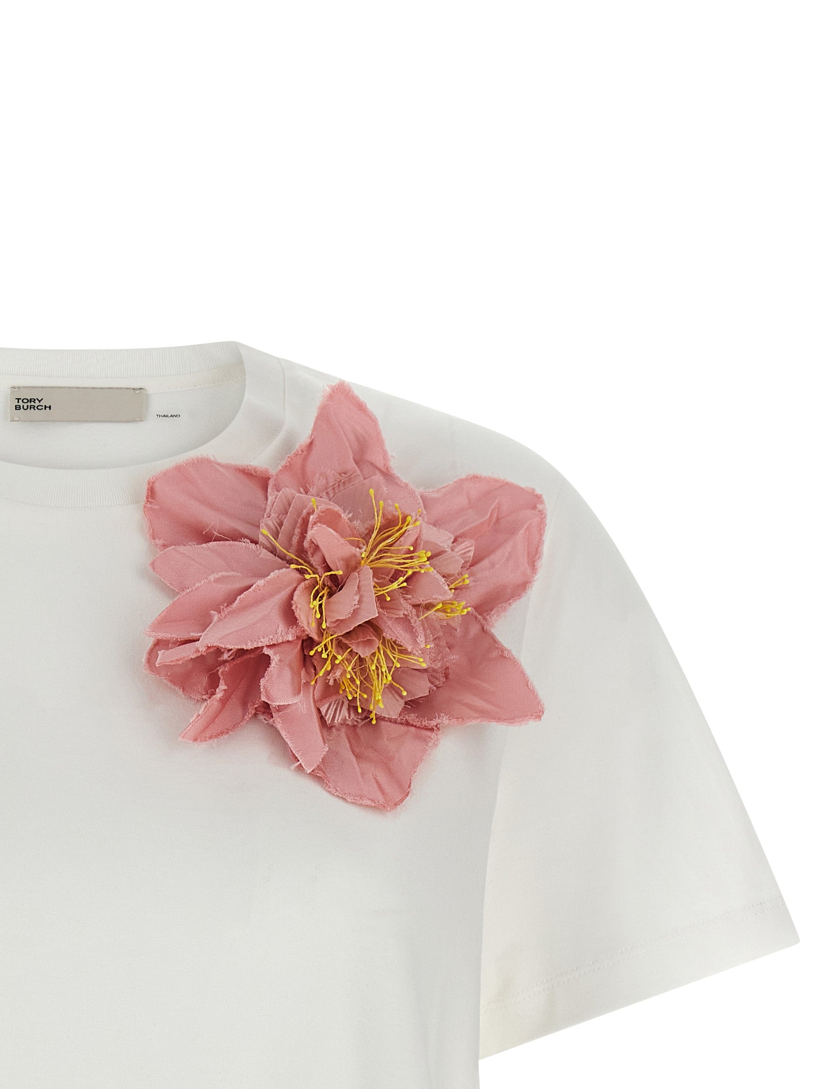 Indulge in the Tory Burch Floral Applique T-shirt, a luxurious 100% cotton piece that embodies elegance and artistry, perfect for the discerning wardrobe.