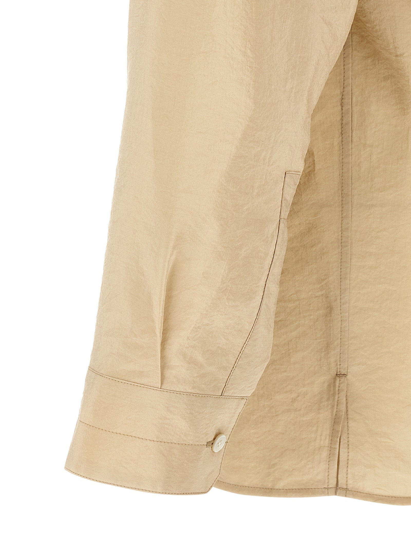 Discover the Lemaire Beige Silk Blouse, a masterpiece of dry silk elegance, featuring a convertible collar and mother-of-pearl buttons, perfect for the discerning wardrobe.