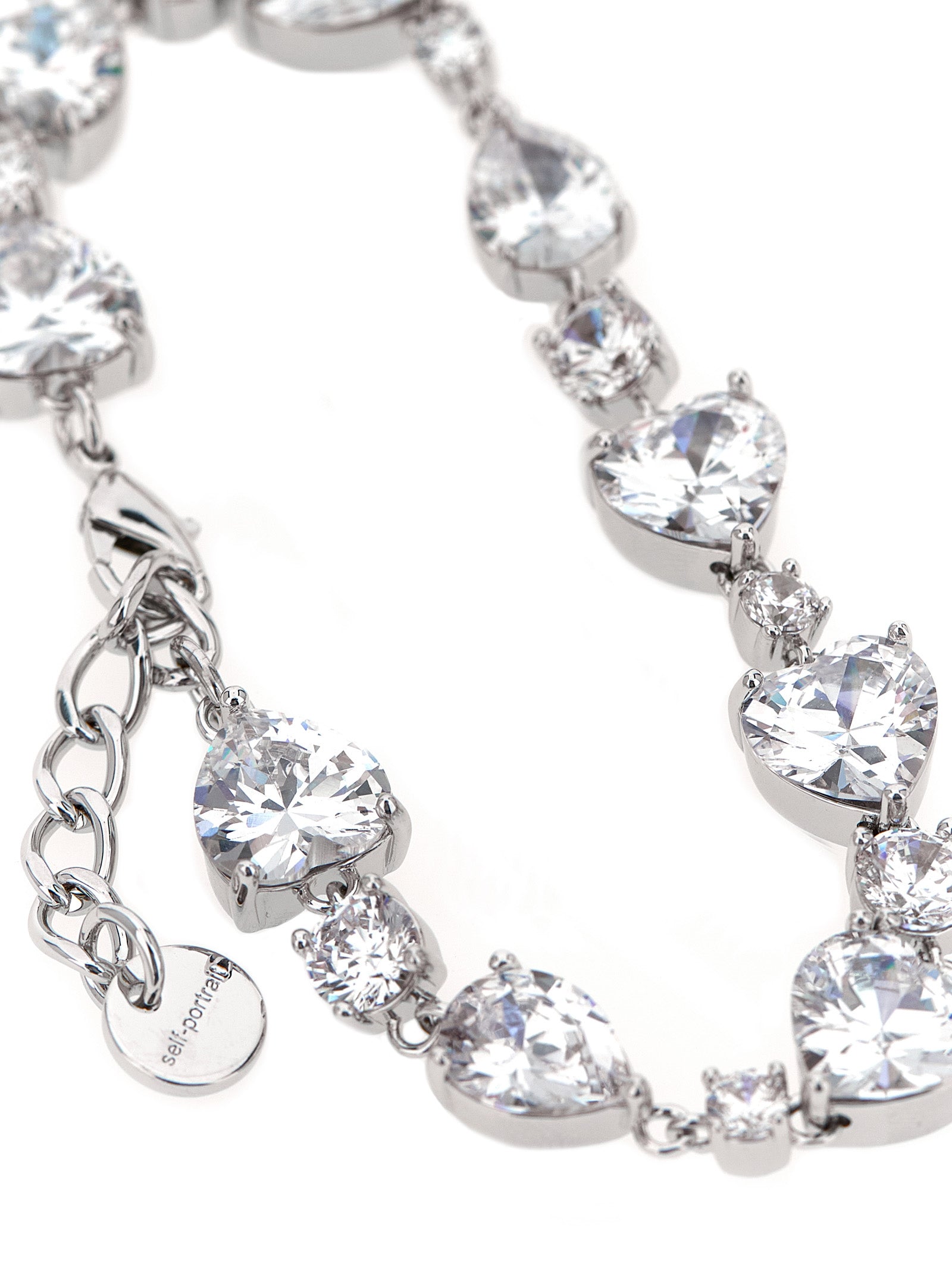 Elevate your elegance with the Self-Portrait Silver Brass Bracelet, a stunning fusion of heart-shaped crystals and silver-plated brass, designed for those who dare to dazzle.