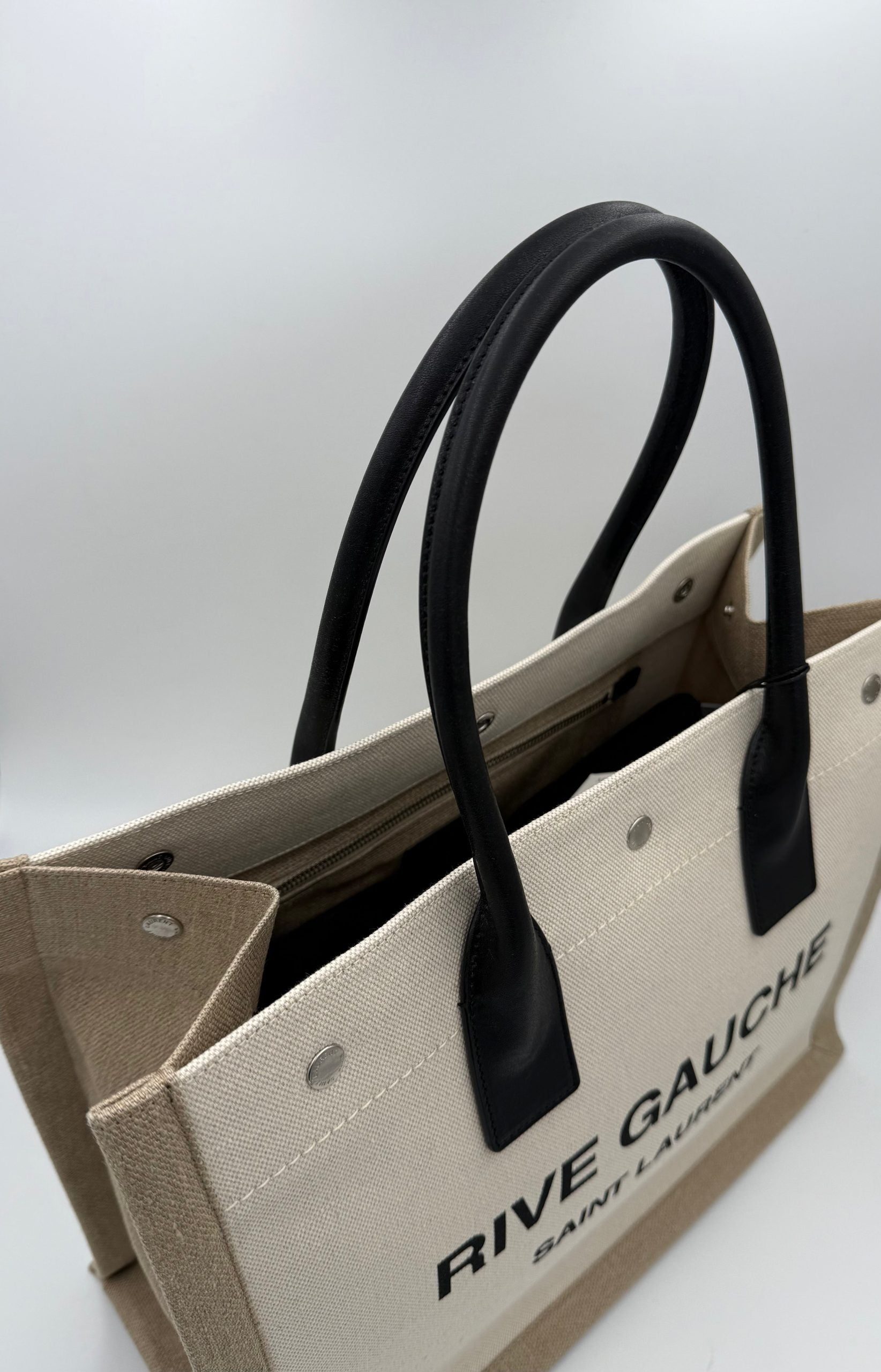 Experience the allure of the Saint Laurent Rive Gauche Medium Tote Bag, a timeless blend of scratch-resistant leather and fabric, embodying luxury and sophistication for every occasion.