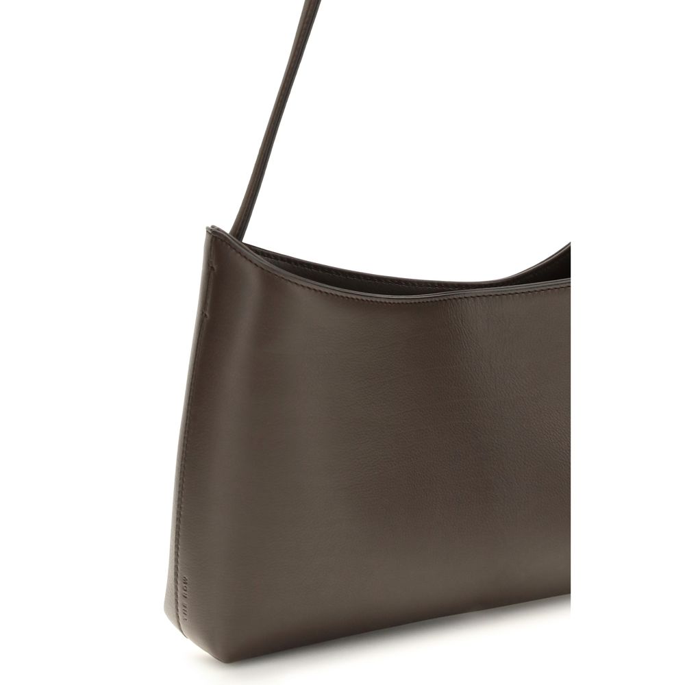 Indulge in the exquisite elegance of The Row's Brown Calf Leather Bos Taurus Shoulder Bag, a timeless accessory crafted from luxurious materials for the discerning individual.