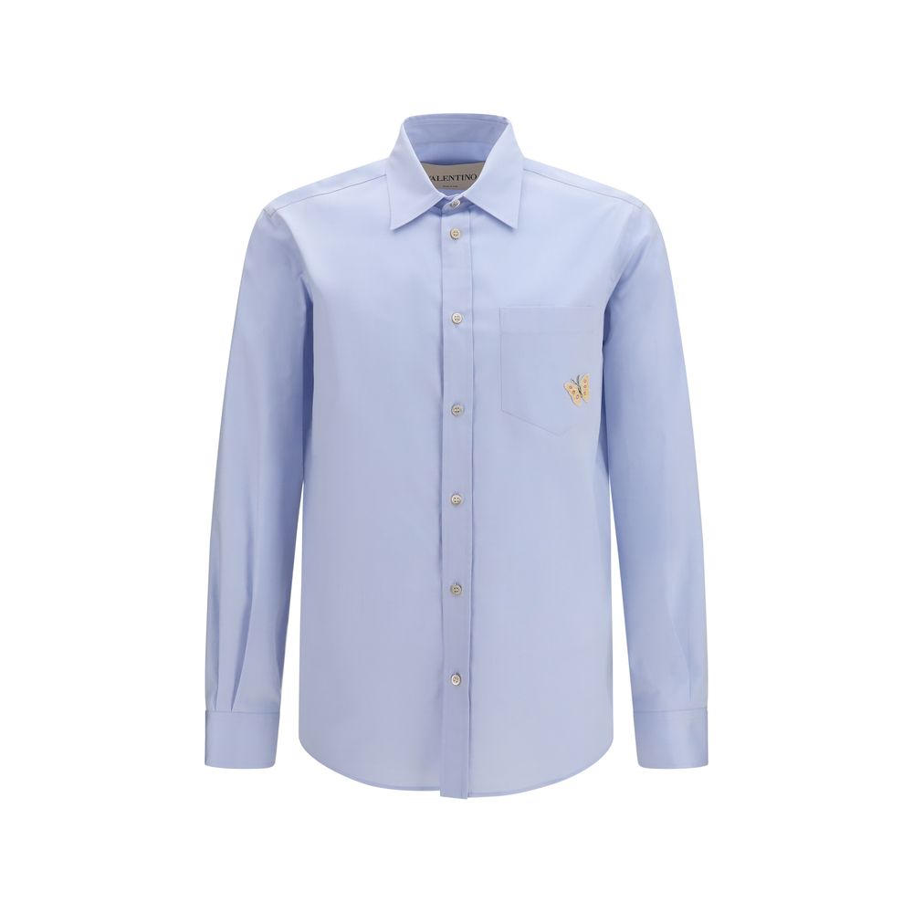 Discover the Valentino Garavani Blue Cotton Dress Shirt, a masterpiece of soft cotton and exquisite butterfly embroidery, embodying timeless elegance and refined style.