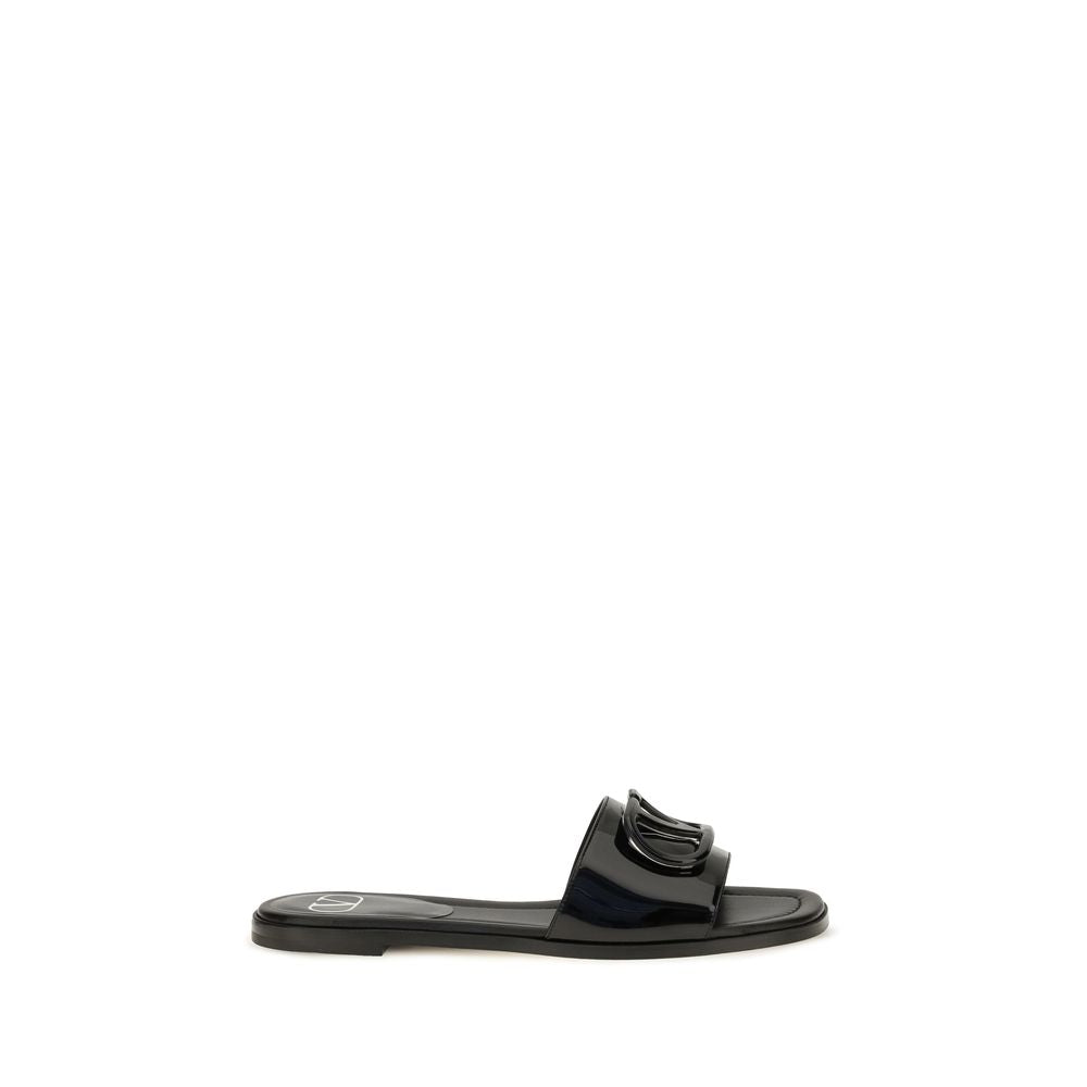 Indulge in the exquisite elegance of Valentino Garavani's Black Calf Leather Bos Taurus Flat Sandals, a masterpiece of minimalism and comfort for the discerning individual.