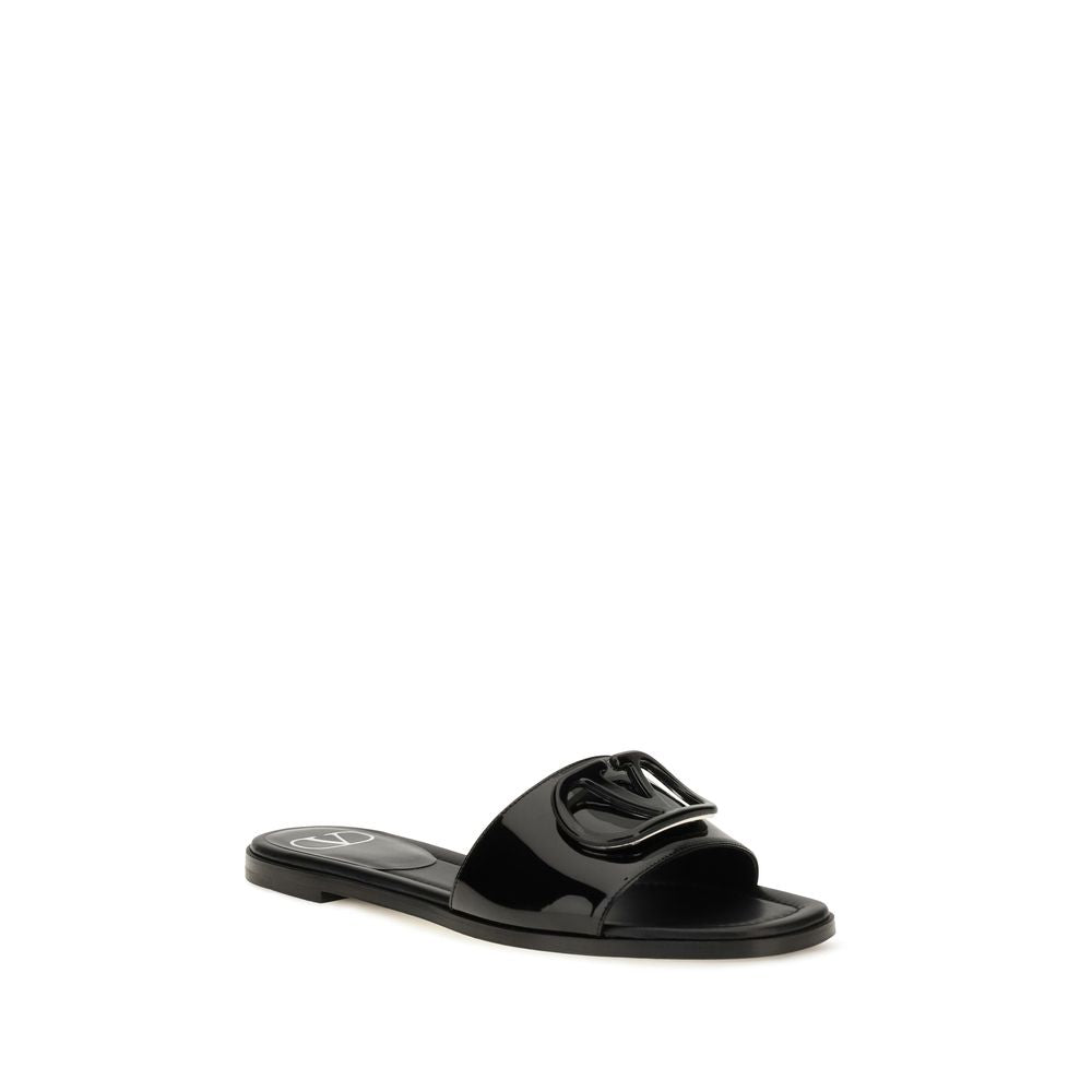 Indulge in the elegance of Valentino Garavani's Black Calf Leather Bos Taurus Flat Sandals, a masterpiece of minimalism crafted for those who appreciate refined luxury and effortless style.